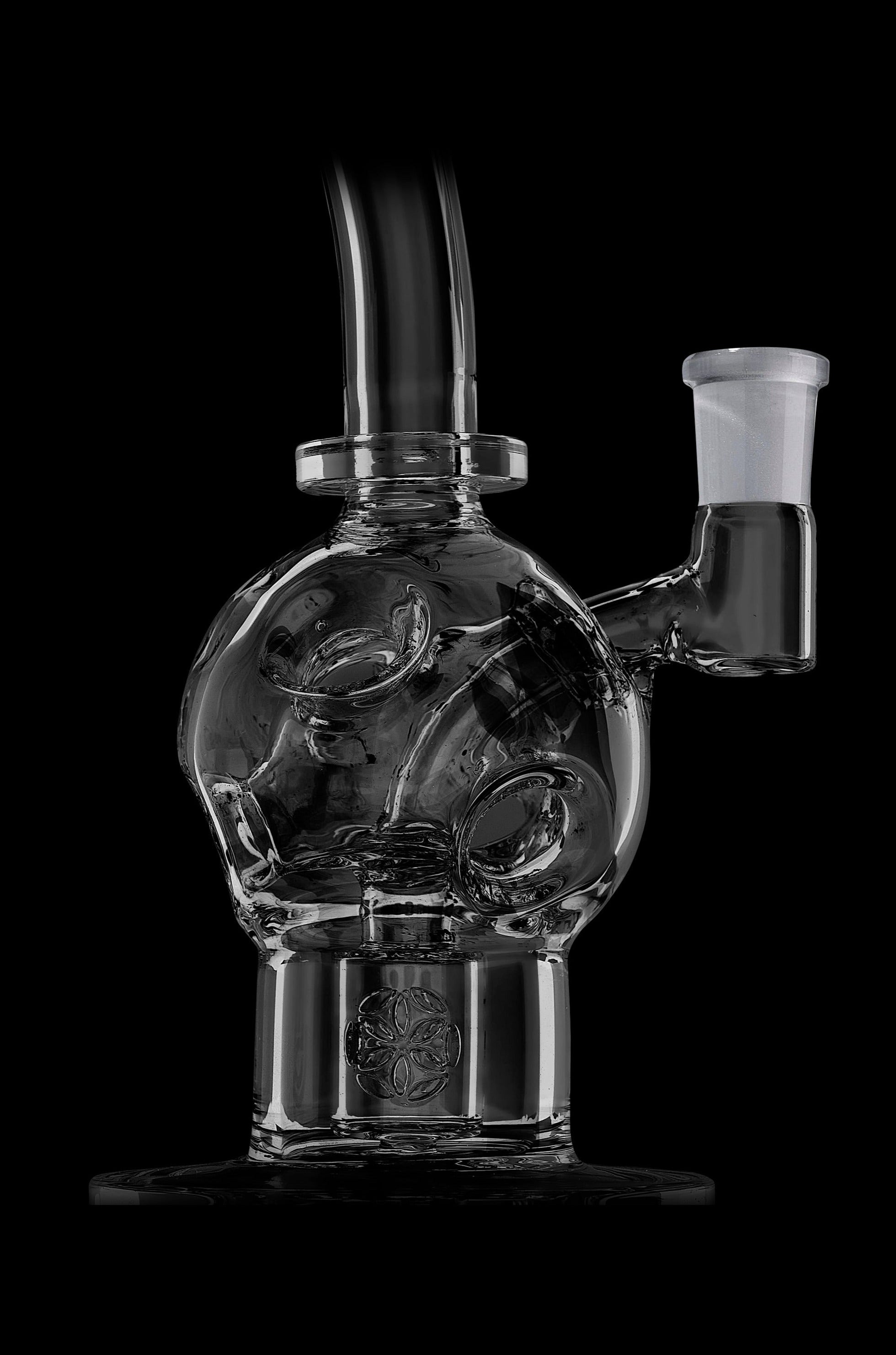 Clear glass water pipe (bubbler) with intricate swirling design and etched floral base, isolated on black.