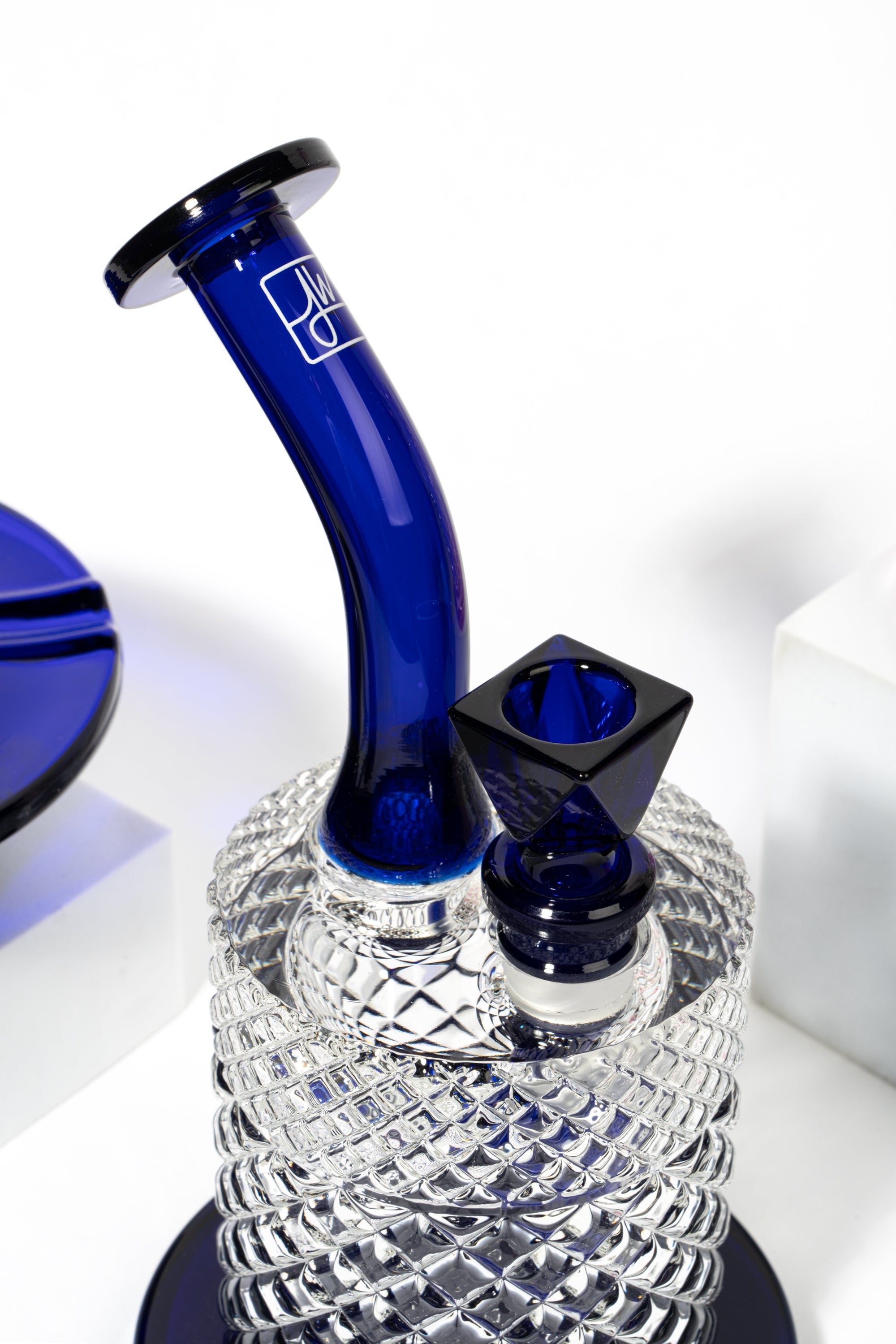 Blue and clear glass water pipe (bong) with a geometric textured base.