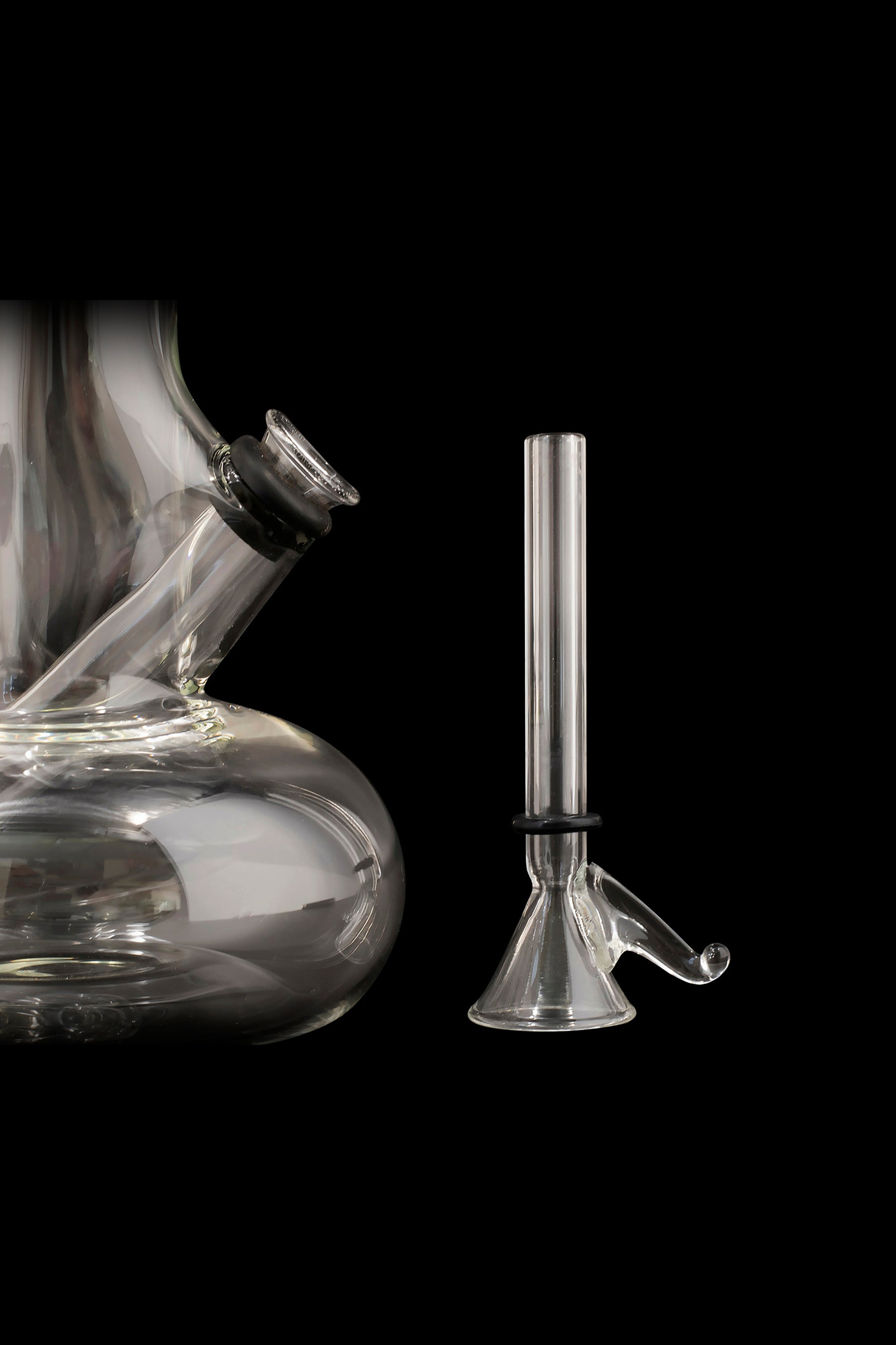 Glass bong and downstem against a black background.