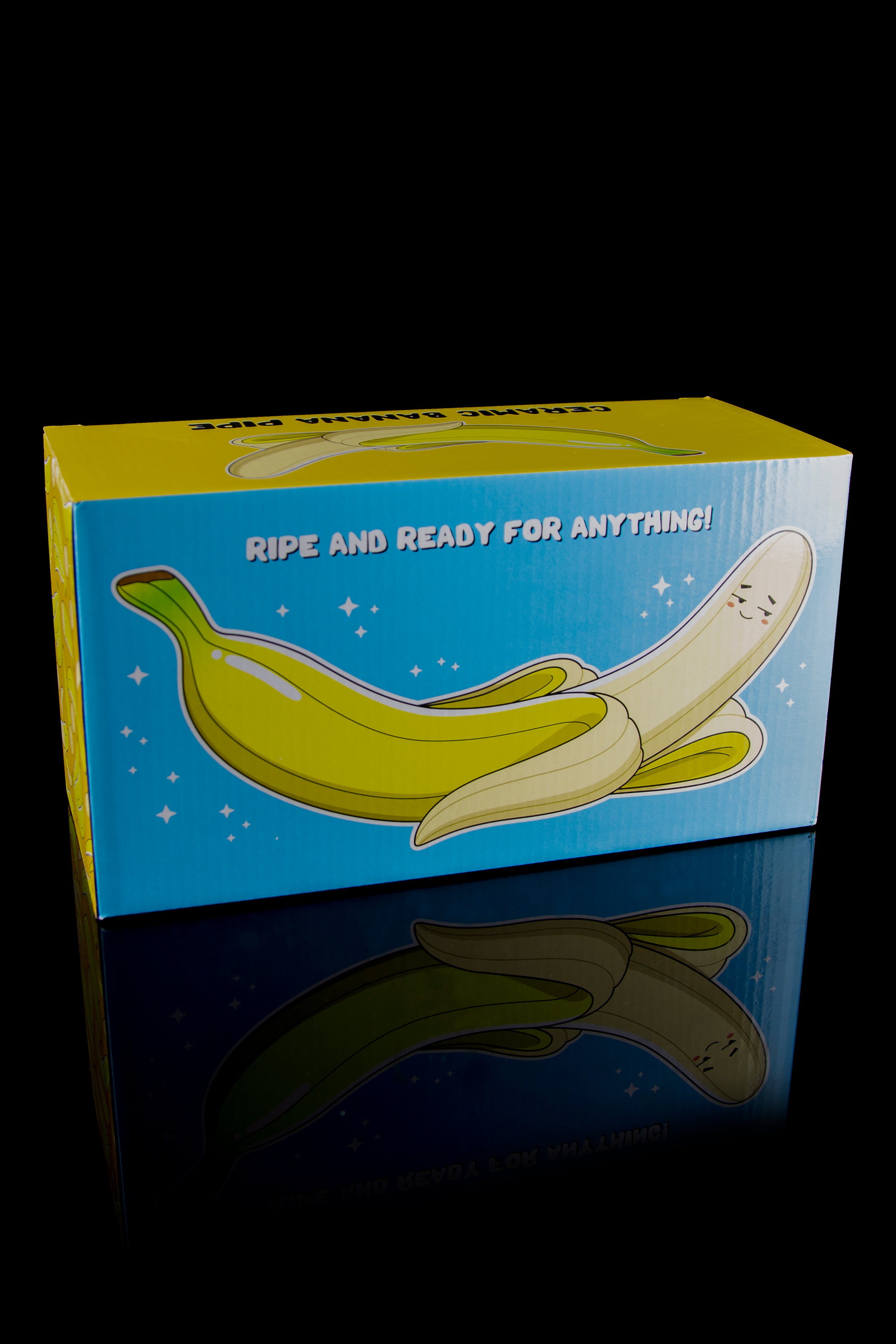 Blue box displaying a yellow banana-shaped glass pipe with the text “Ripe and Ready for Anything!” and a reflective surface.