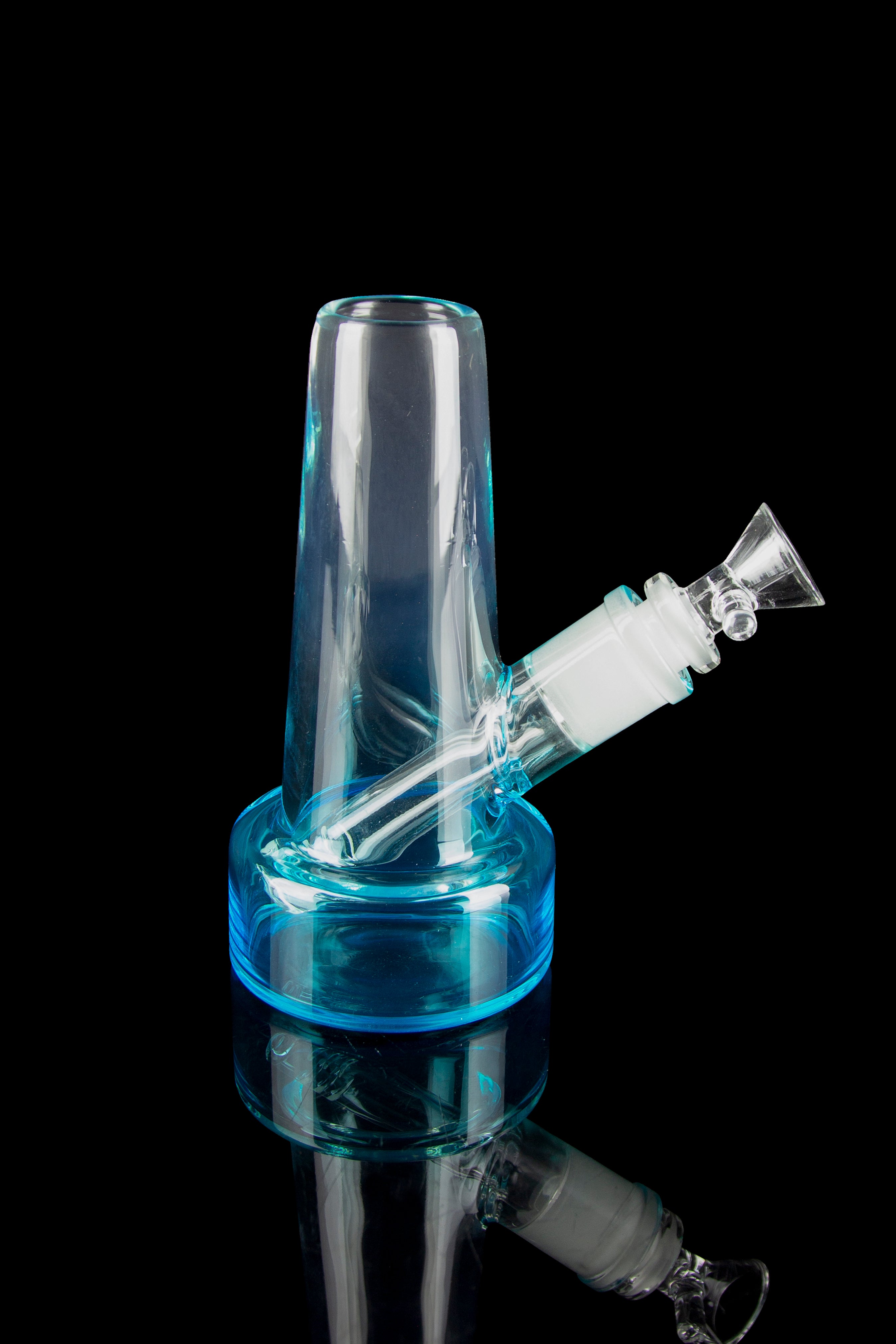 Blue glass bubbler with a visible bowl and downstem, reflecting on a black surface.