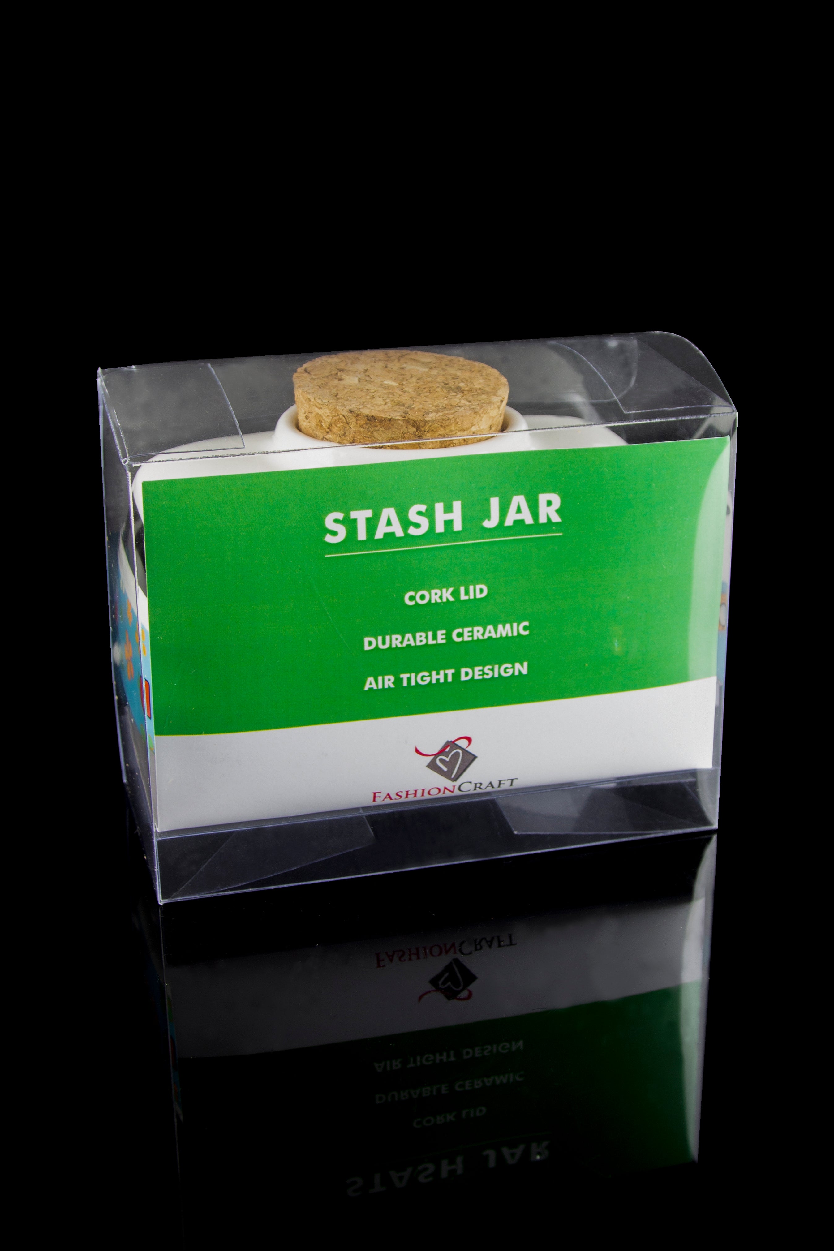 Clear plastic packaging showcasing a green “STASH JAR” with a cork lid, labeled with features like “DURABLE CERAMIC” and “AIR TIGHT DESIGN,” reflected on a glossy surface.