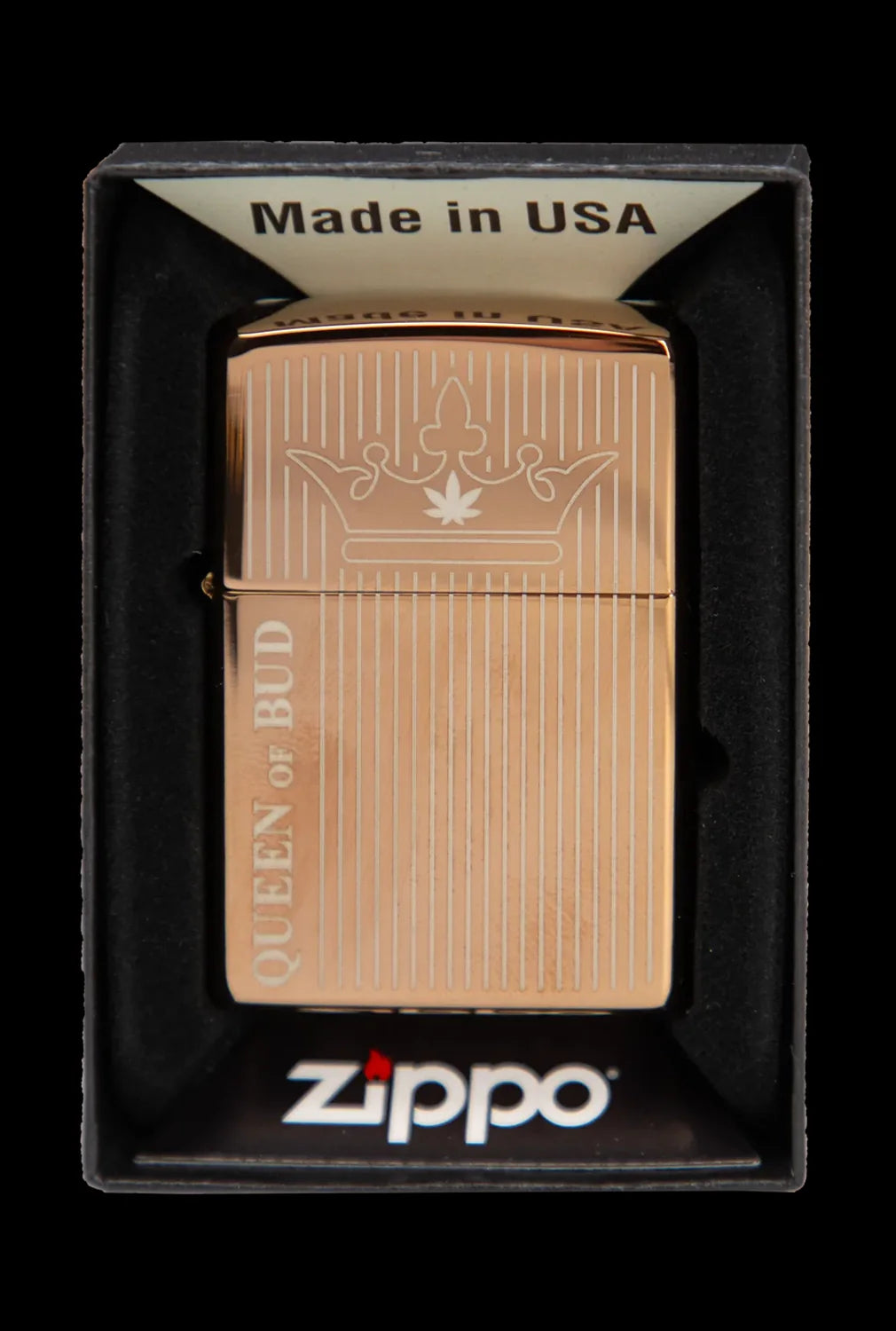 Gold Zippo lighter with a cannabis leaf crown design and "Queen of Bud" text, in its packaging.