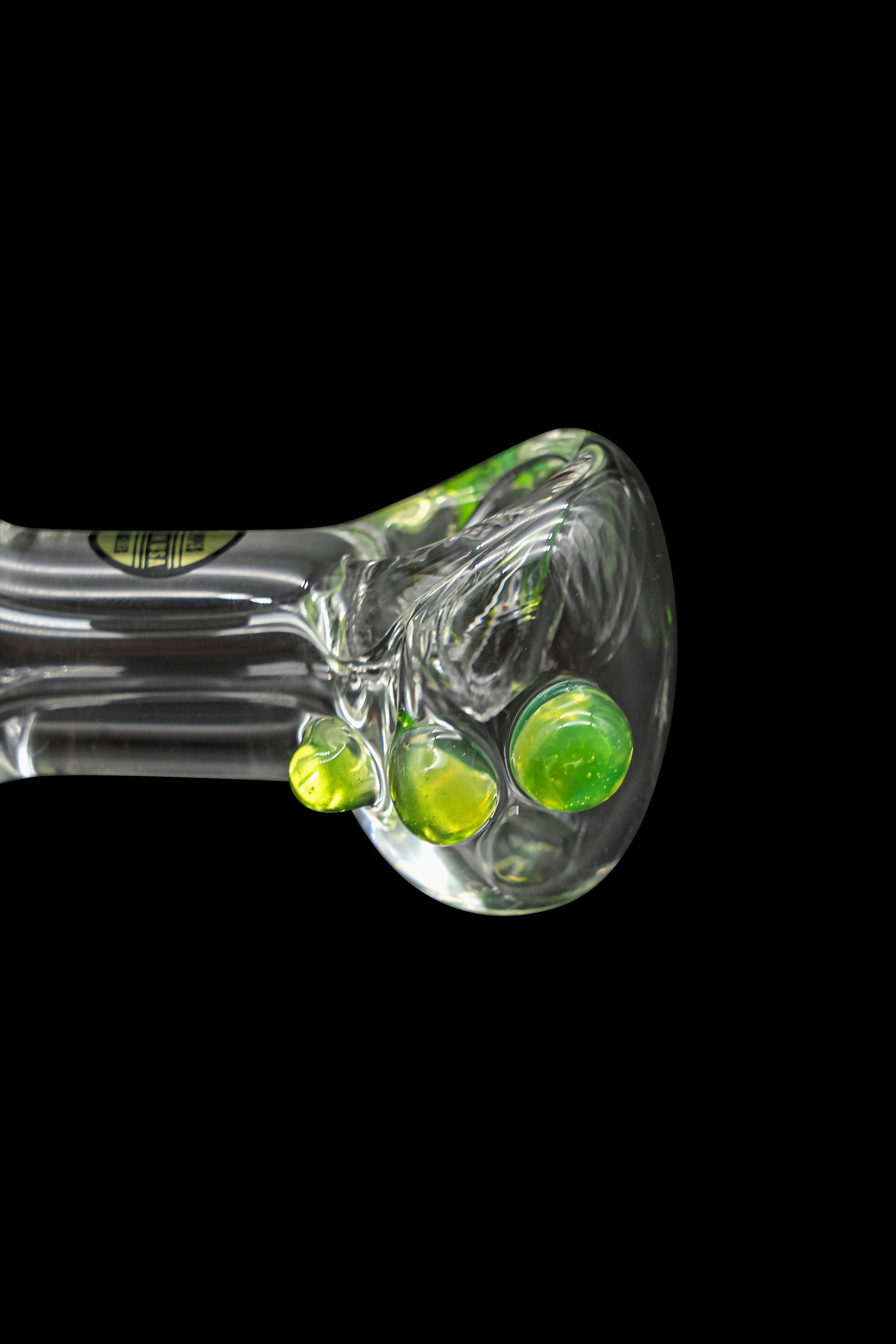 Green glass cannabis spoon pipe with colorful bubbles.
