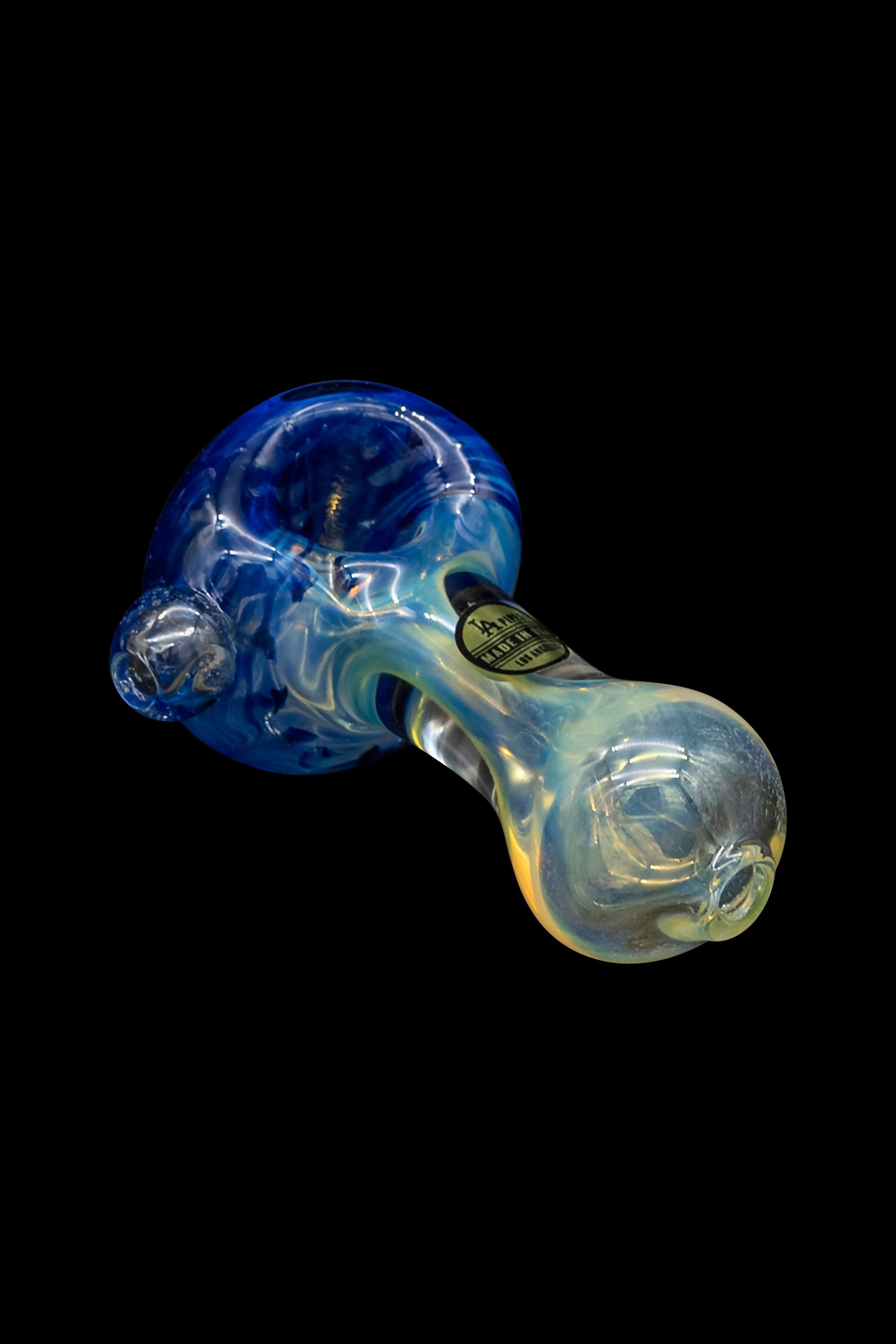 Hand-blown glass cannabis pipe with blue and yellow swirls against a black background.