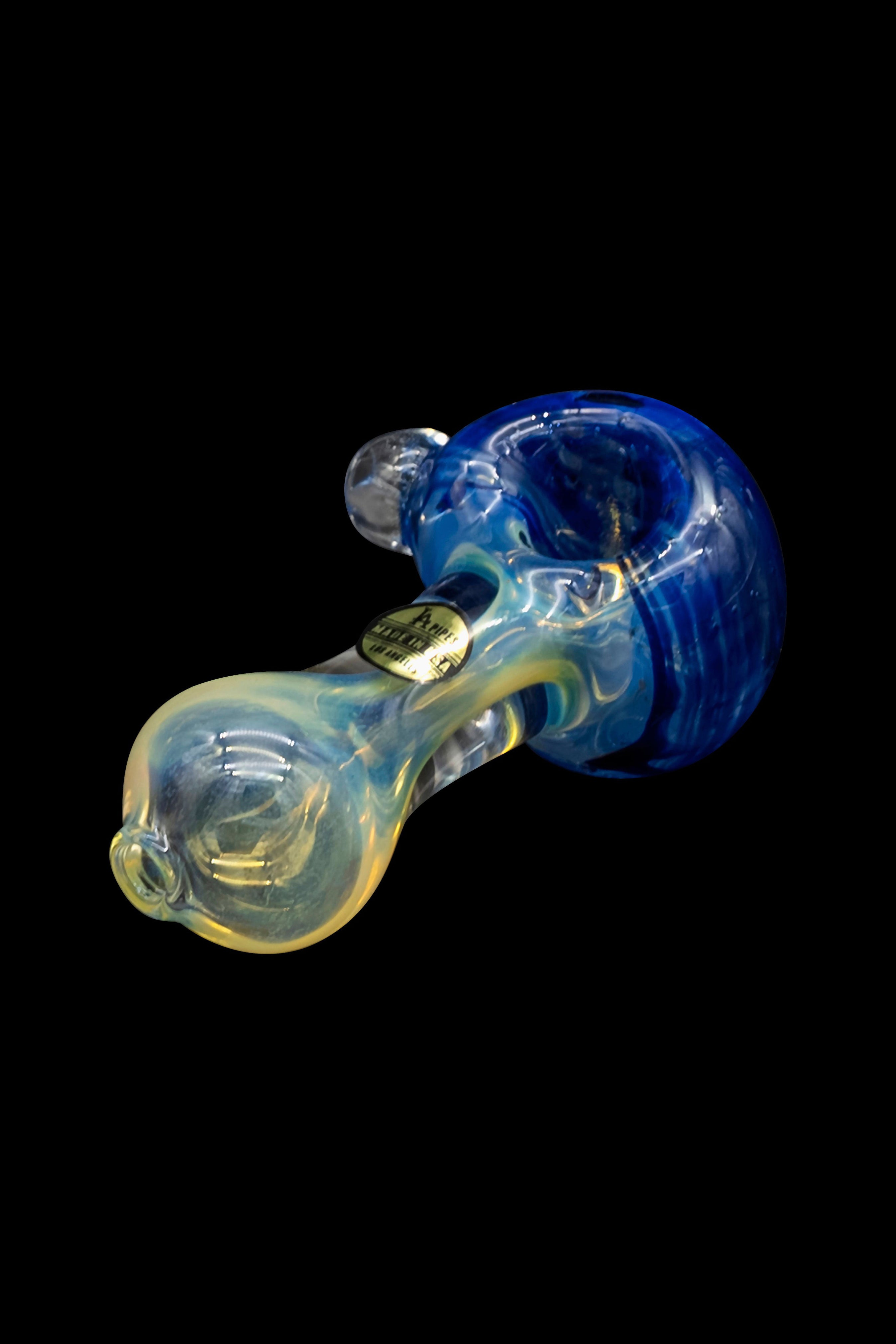 Hand-blown glass pipe with blue and yellow swirling patterns, isolated on a black background.