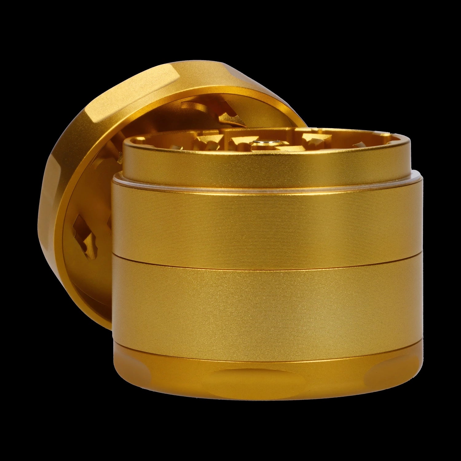 Close-up front angle of the Famous Design-Surrender Aluminum 3 Stage Grinder-Gold showing its metallic gold stacked chambers and exposed toothed interior against a black background