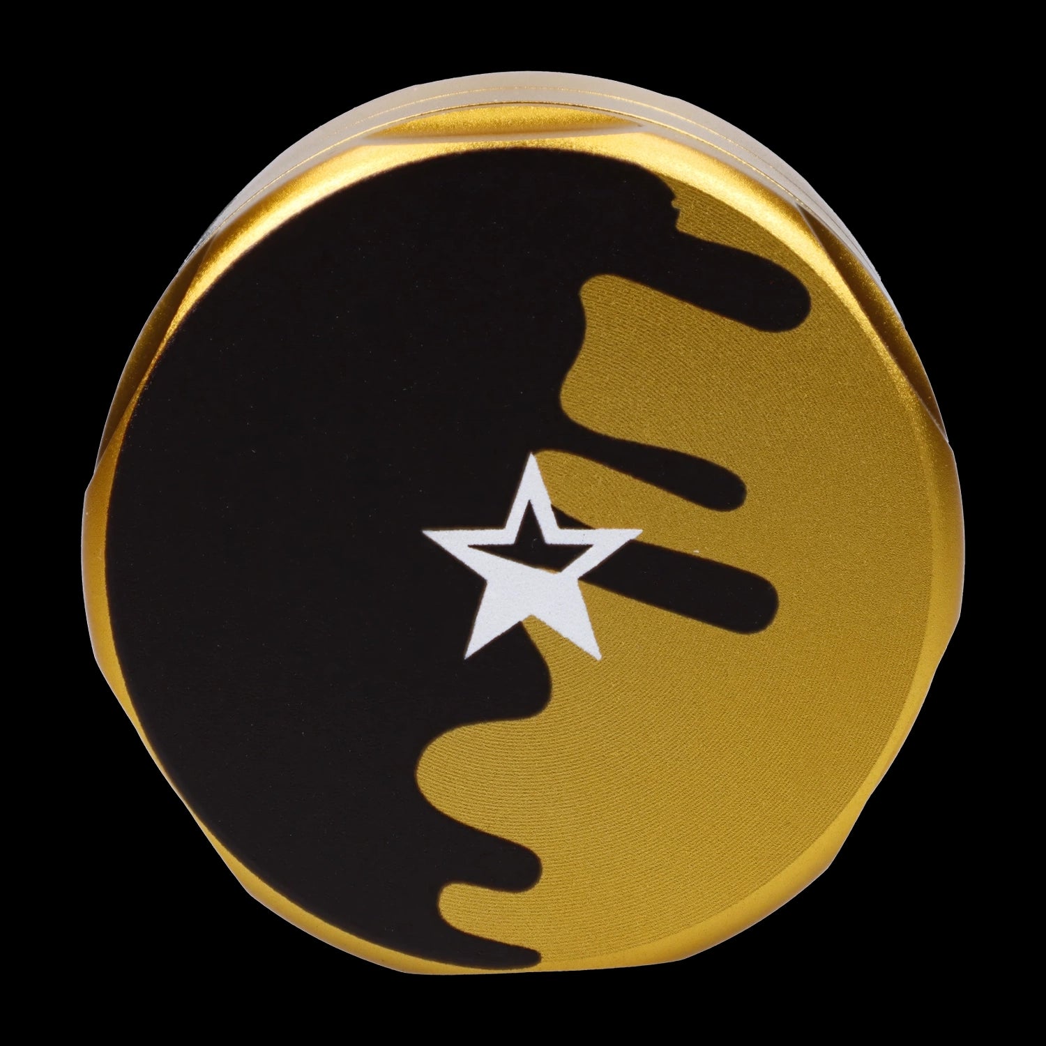 Close-up top view of the gold Famous Design-Surrender Aluminum 3 Stage Grinder-Gold showing a black drip motif and white star on the lid against a black background.