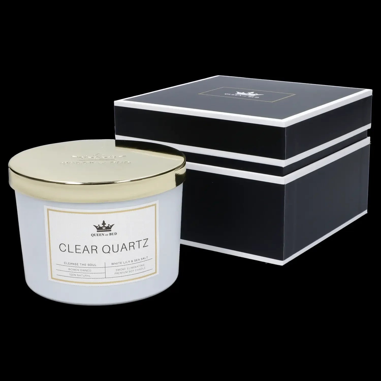 A glass jar candle labeled “Clear Quartz” by Queen of Bud, with scent notes of white lily & sea salt, presented in a black gift box.
