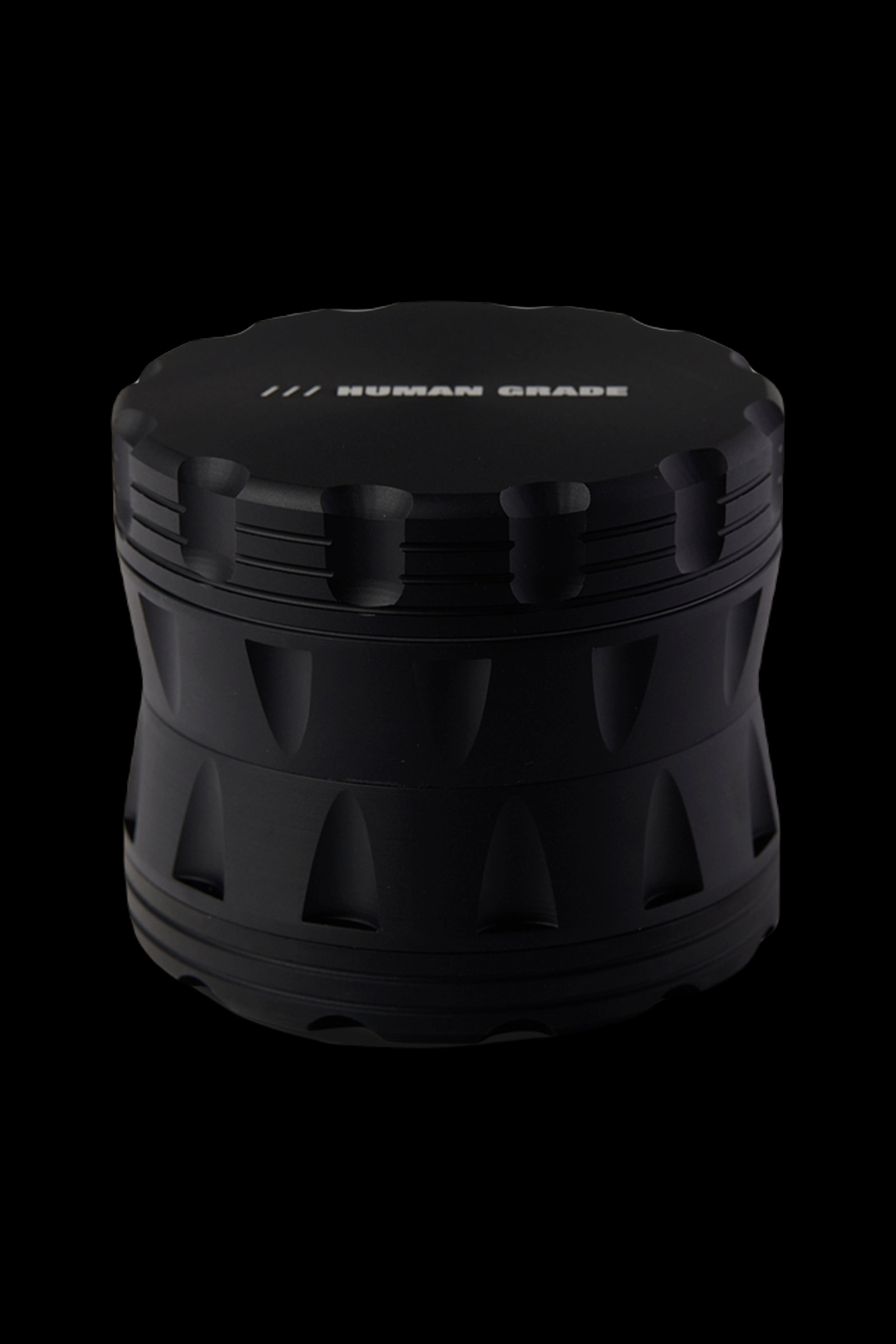 Black cannabis grinder with "HUMAN GRADE" text on top.