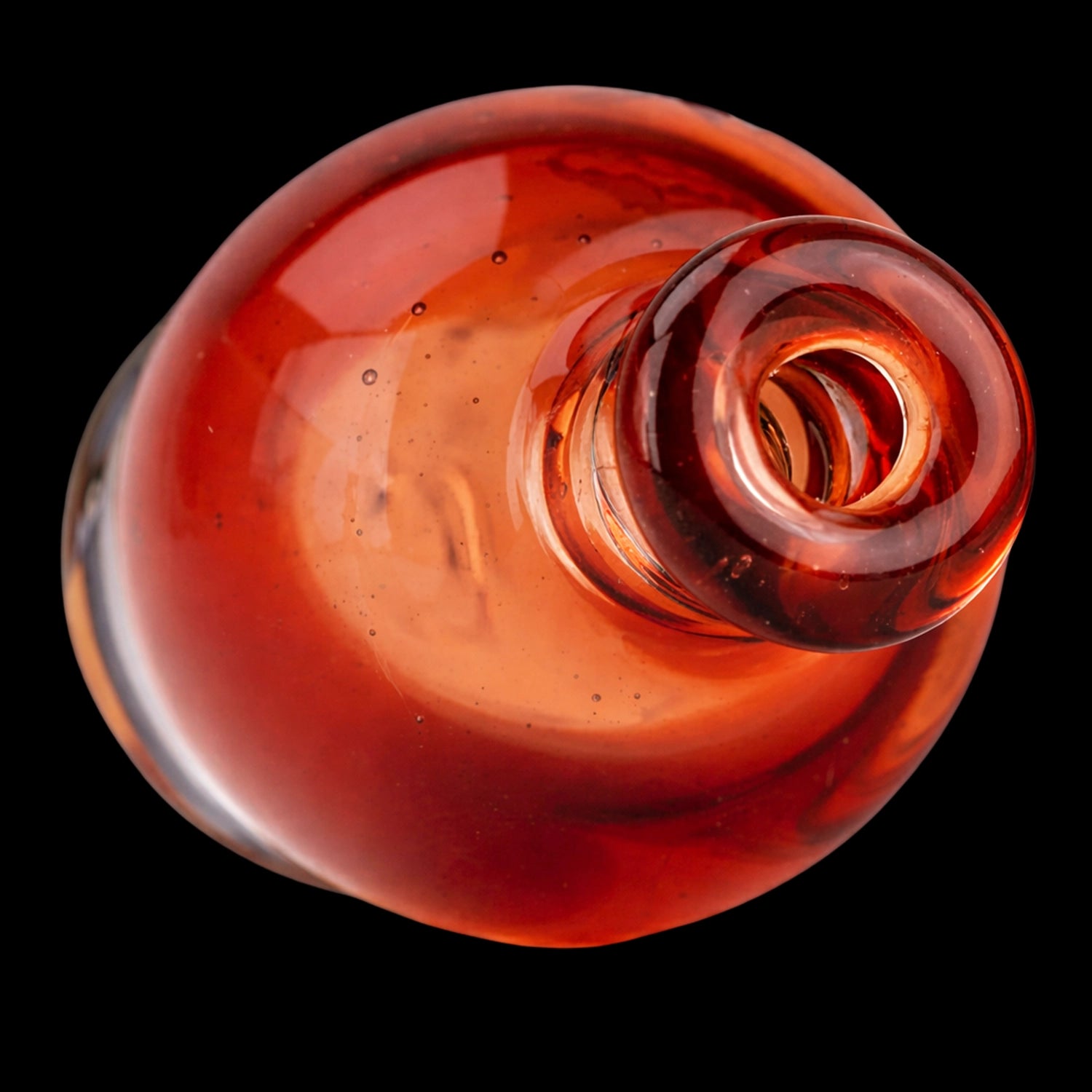 Top-down close-up of the Empire Glassworks Puffco Pivot Glass Mouthpiece - Transparent Red showing its glossy red glass rim and rounded interior against a black background