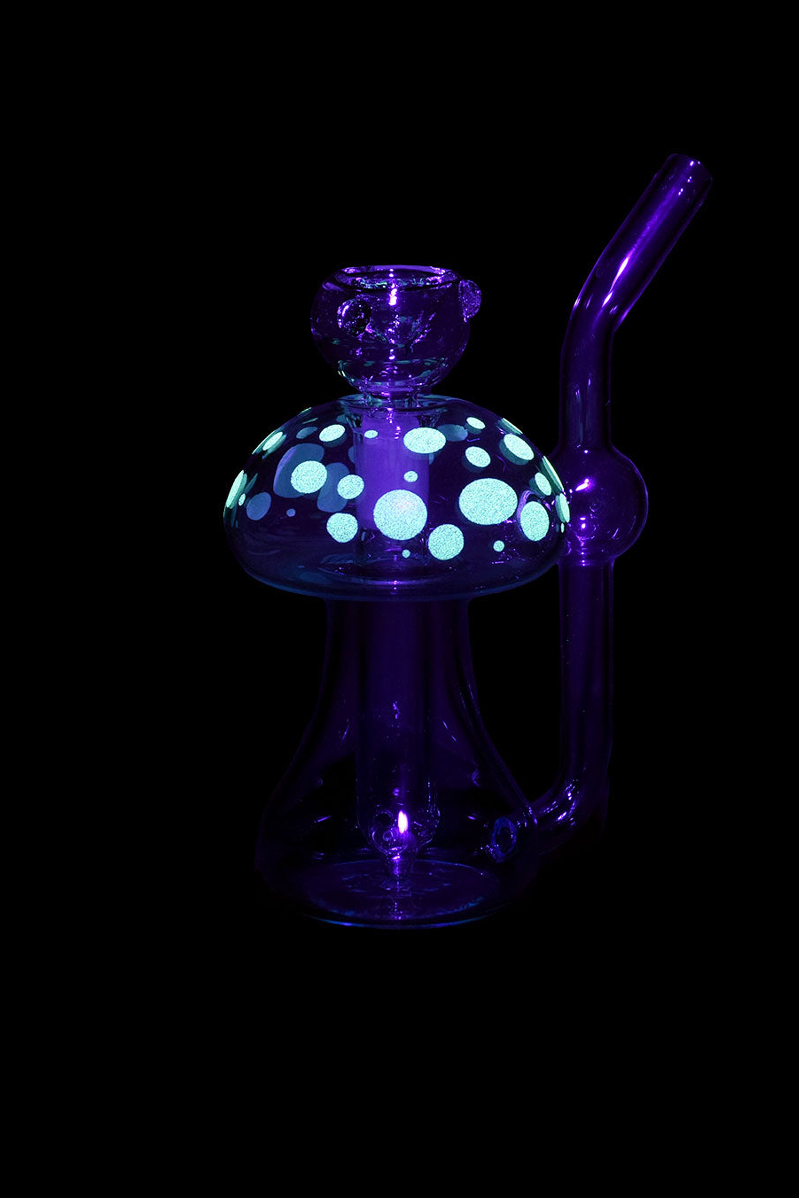 Purple glass mushroom-shaped dab rig with teal polka dots, isolated on a black background.