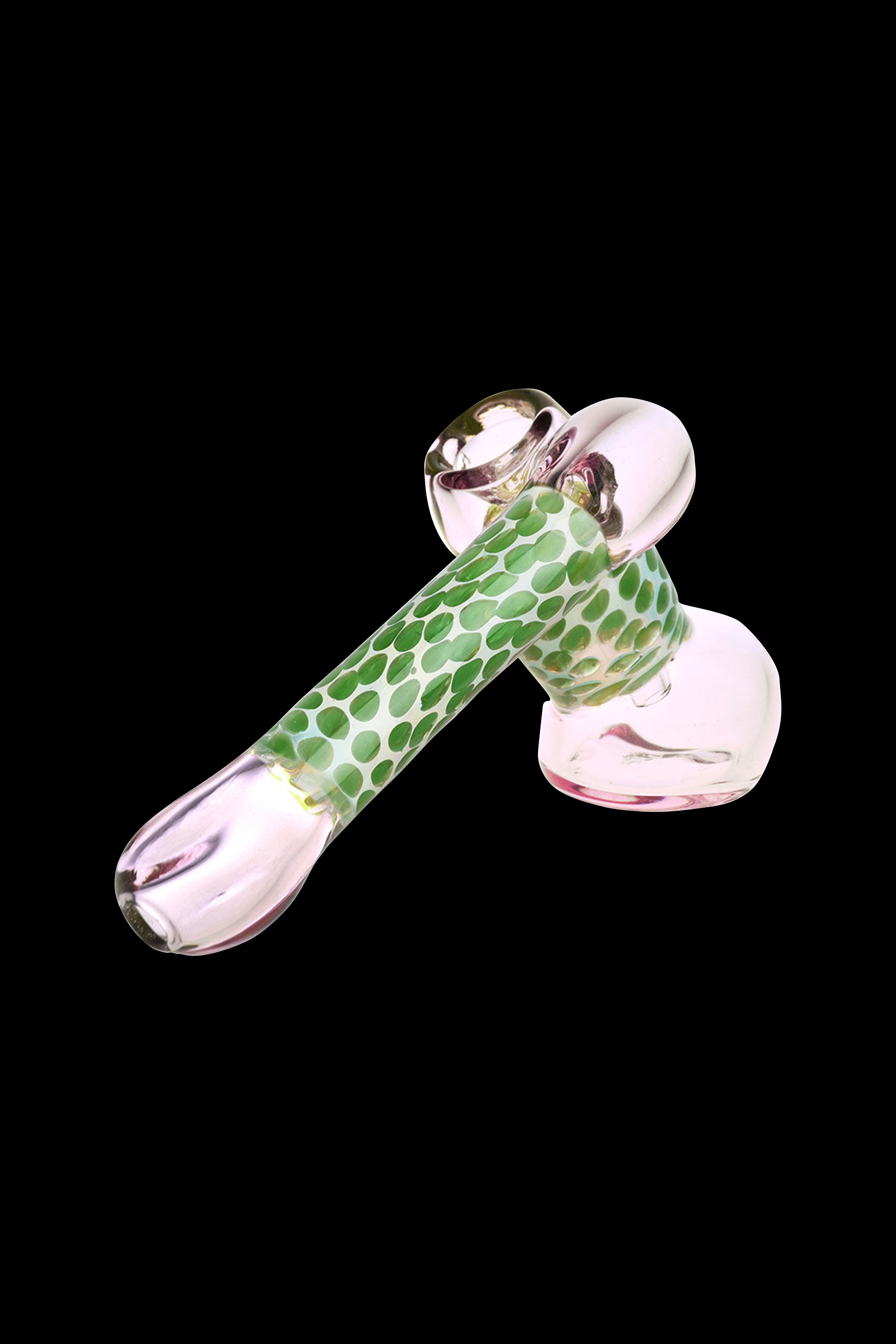 Pink glass pipe with green speckled detailing, isolated on a black background.