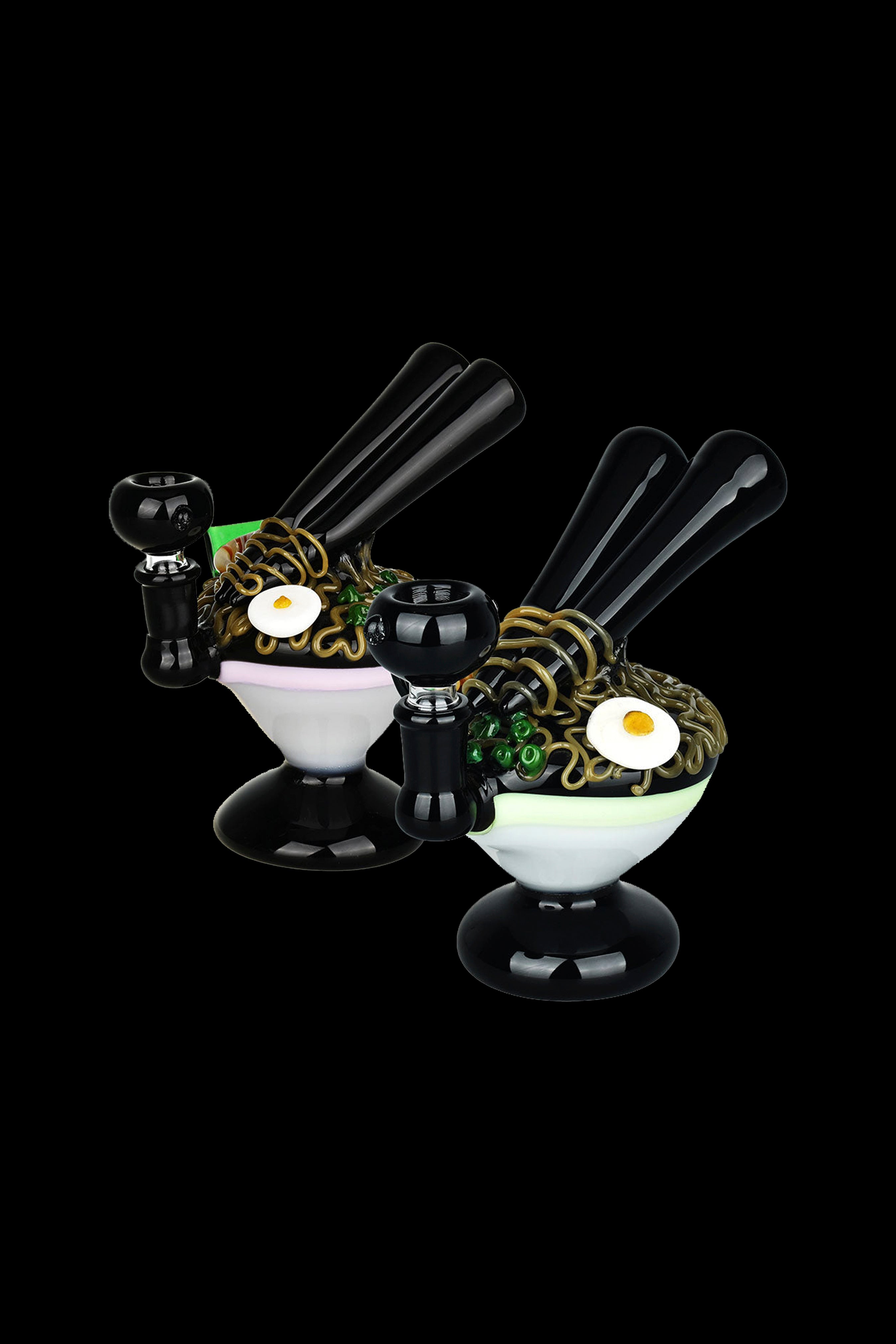 Black glass dab rigs styled as ramen bowls with coiled glass “noodles” and a fried egg-shaped accent, isolated on a black background.
