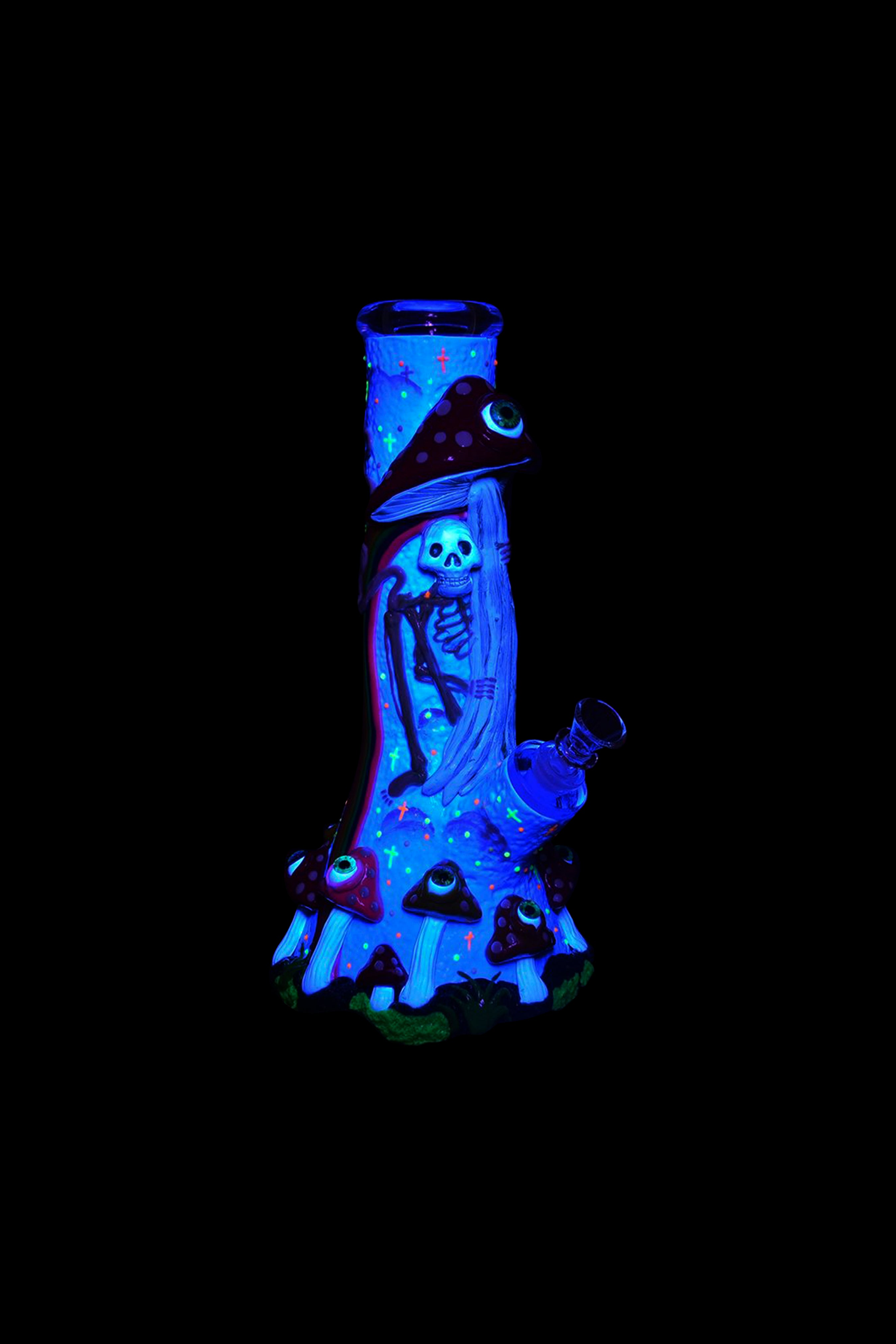 Glow-in-the-dark glass water pipe shaped like a skeleton wearing a witch hat, surrounded by glowing mushrooms.