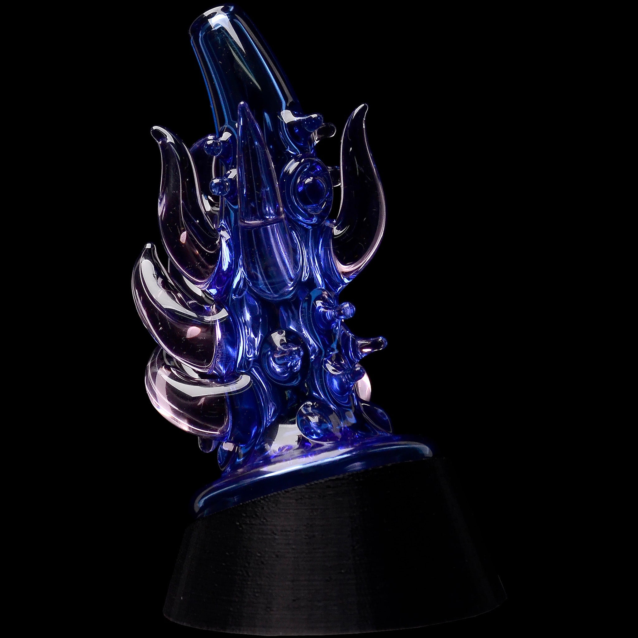 Angled close-up of the Glassic Cosmic Tentacle Puffco Peak Glass Attachment showing iridescent blue tentacle-like glass details against a black background