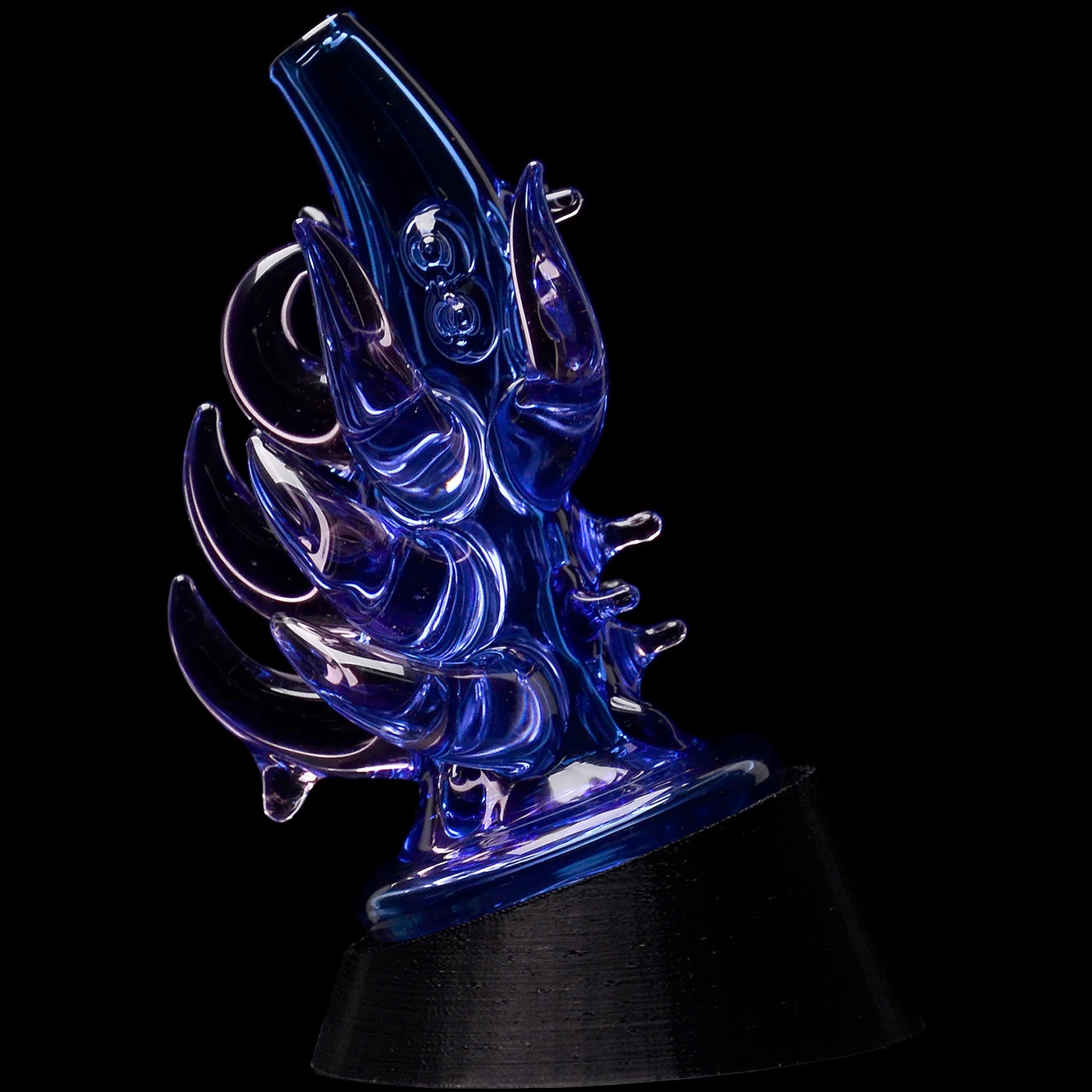 Angled close-up of a blue Glassic Cosmic Tentacle Puffco Peak Glass Attachment with curling, glossy glass tentacles against a black background