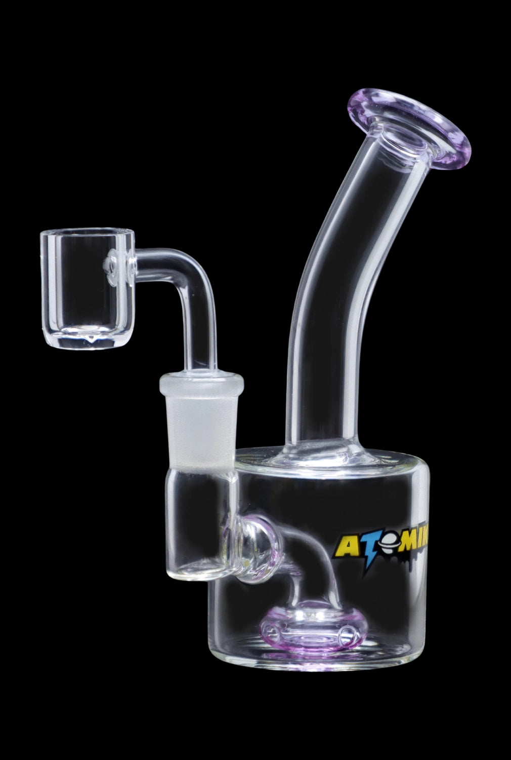 A studio shot of the Atomik Little Dipper Dab Rig, showcasing its compact size and clear glass construction from a three-quarter angle.