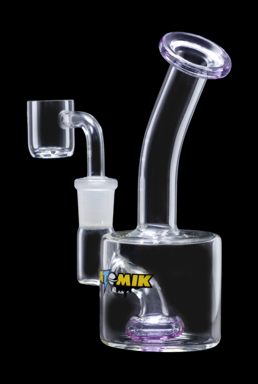 The Atomik Little Dipper Dab Rig appears in a studio shot, highlighting its clear glass construction and compact 5.25-inch size.