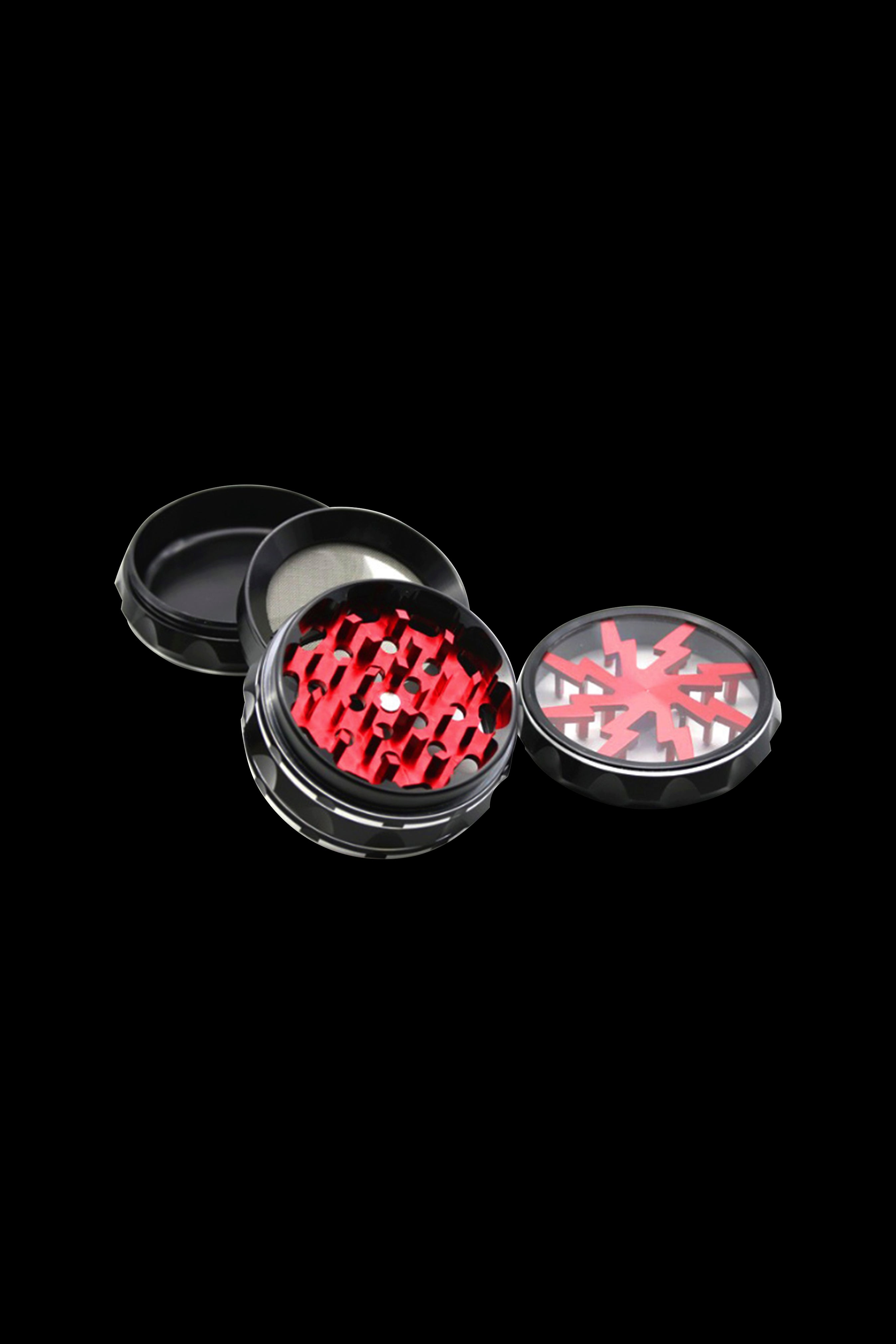 Black and red cannabis grinder with open compartments displaying grinding teeth.