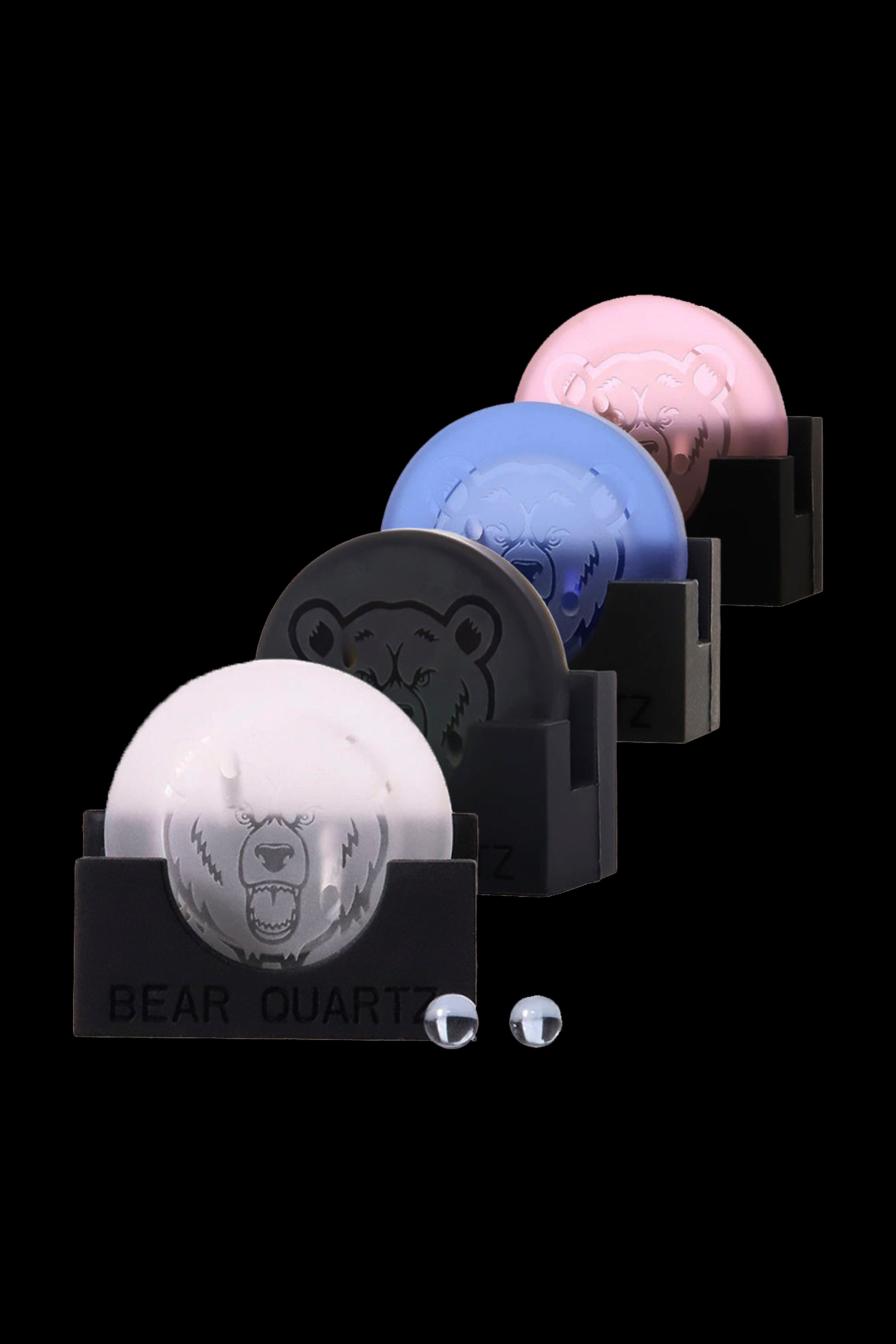 Three clear quartz cannabis water pipes with bear-shaped bases stacked against a black background, displaying different colored translucent bases.