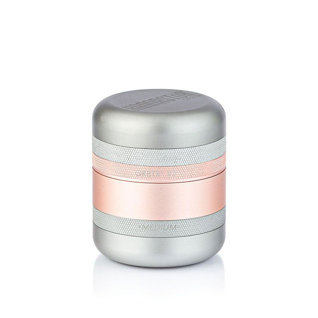 Front-facing studio shot of the metallic RYOT GR8TR Solid Body Grinder with silver and rose-gold stacked bands on a white background
