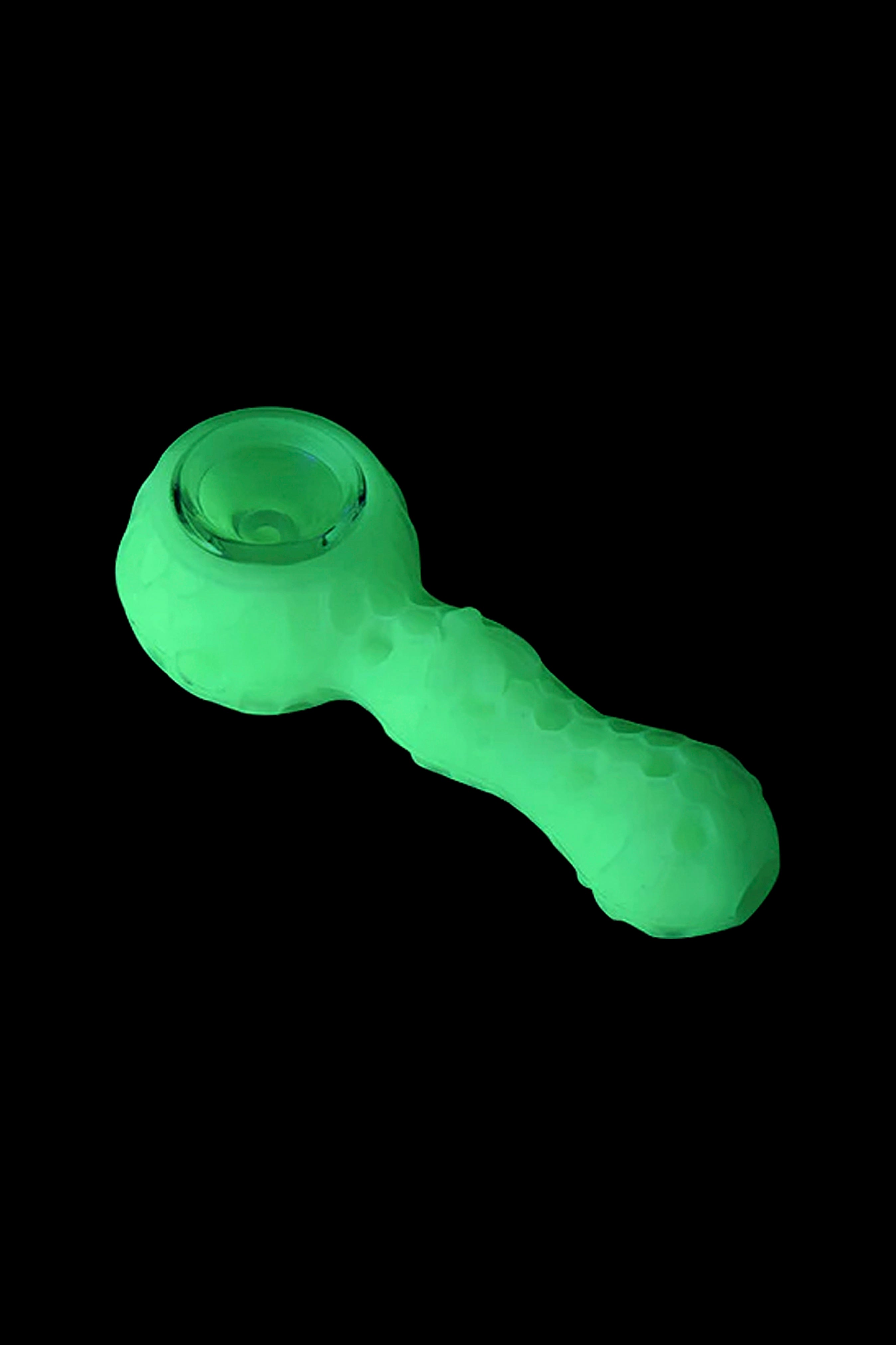 Glowing green silicone cannabis pipe isolated on black.