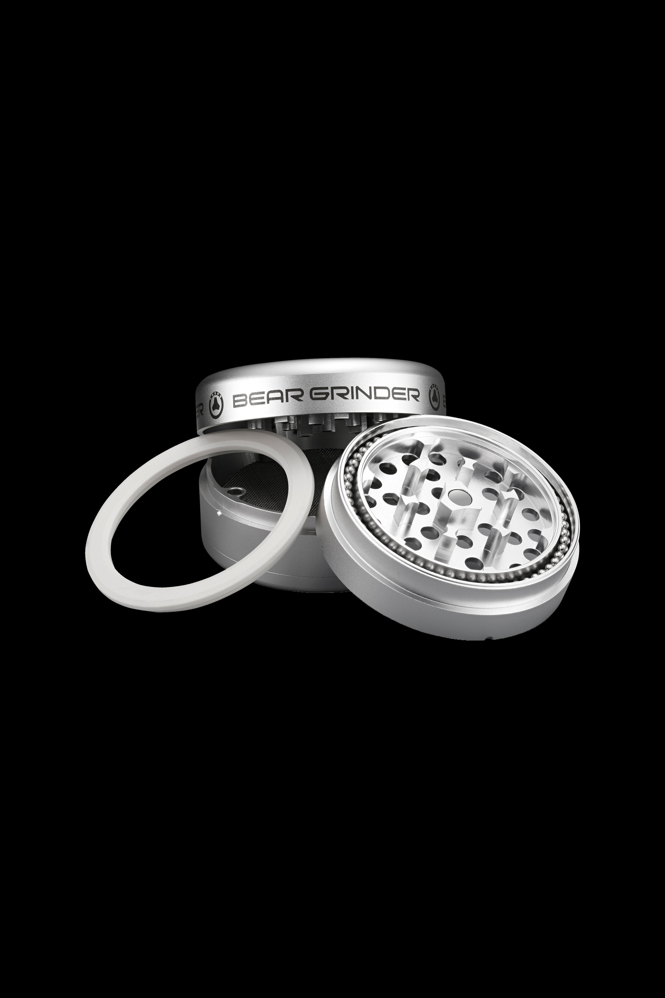 Silver four-piece cannabis grinder with open lid and spare O-ring.