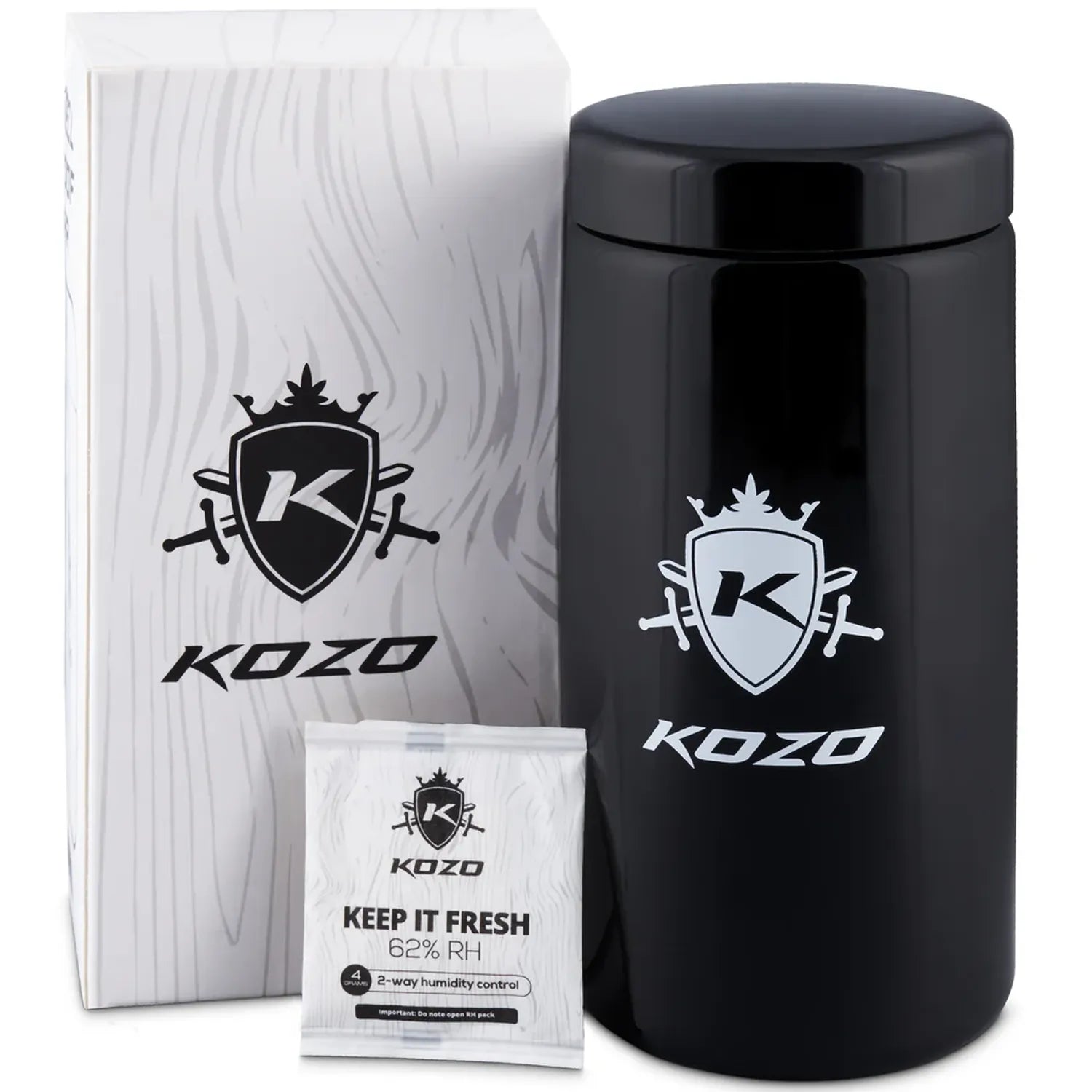 Close-up three-quarter view of a glossy black Kozo Glass jars - 2 OZ cylinder beside its white branded box and a small "Keep It Fresh" humidity packet.