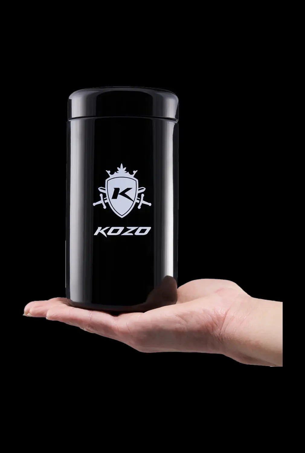 A hand holds a Kozo Glass jars - 1 OZ jar, with focus on the clear glass and rounded form.