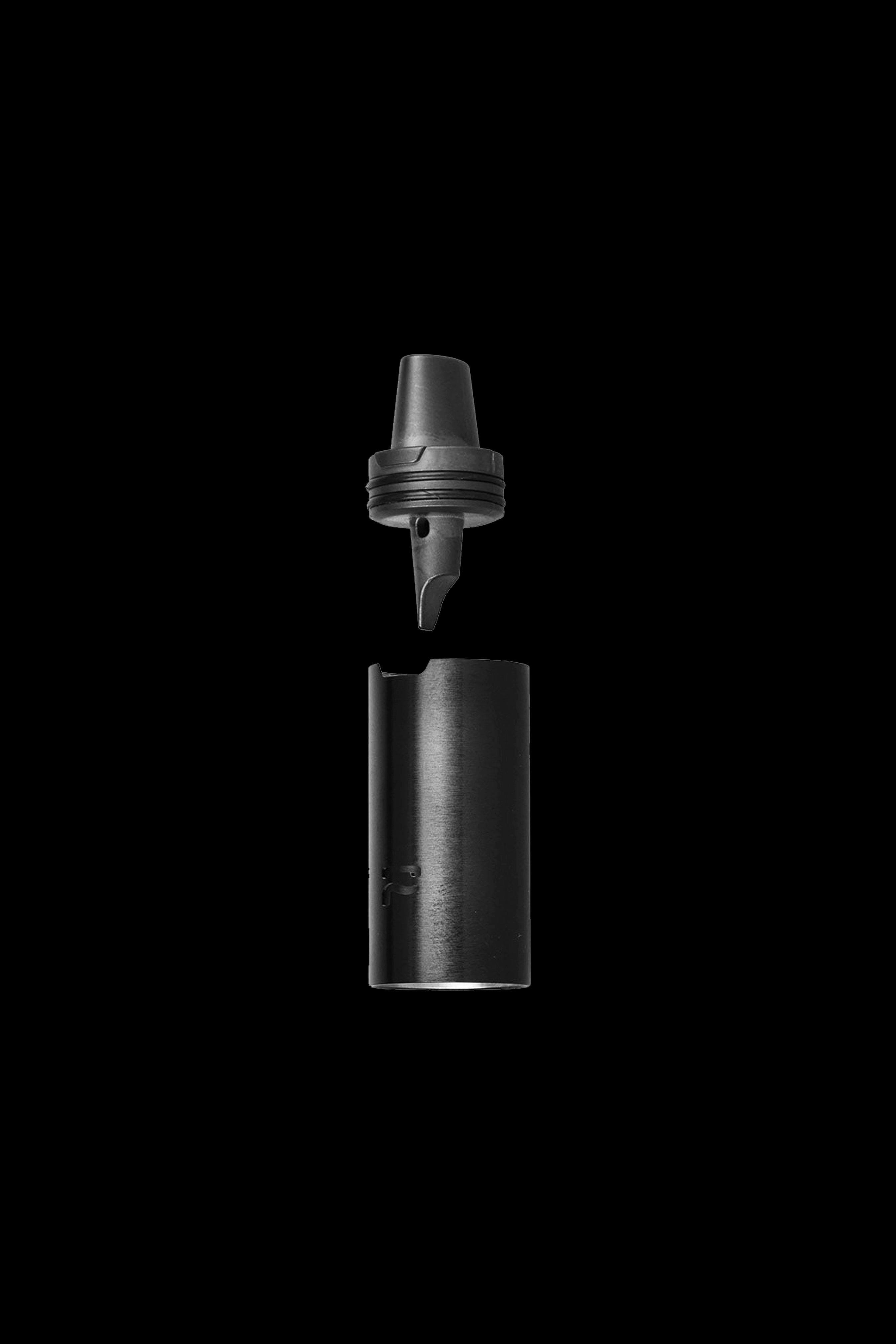 Black cannabis concentrate vaporizer cartridge disassembled, showing the mouthpiece and cylinder separated against a dark background.
