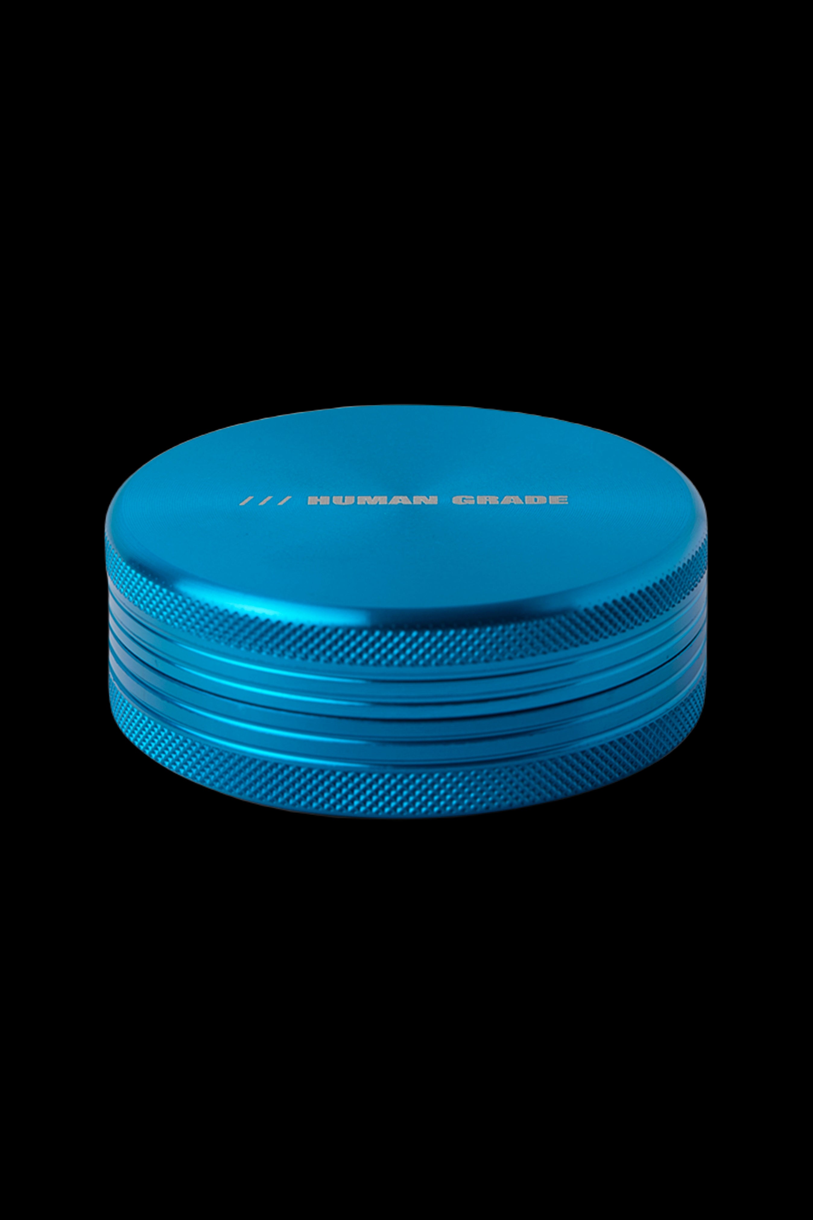Blue metal cannabis grinder with "HUMAN GRADE" text on the lid.