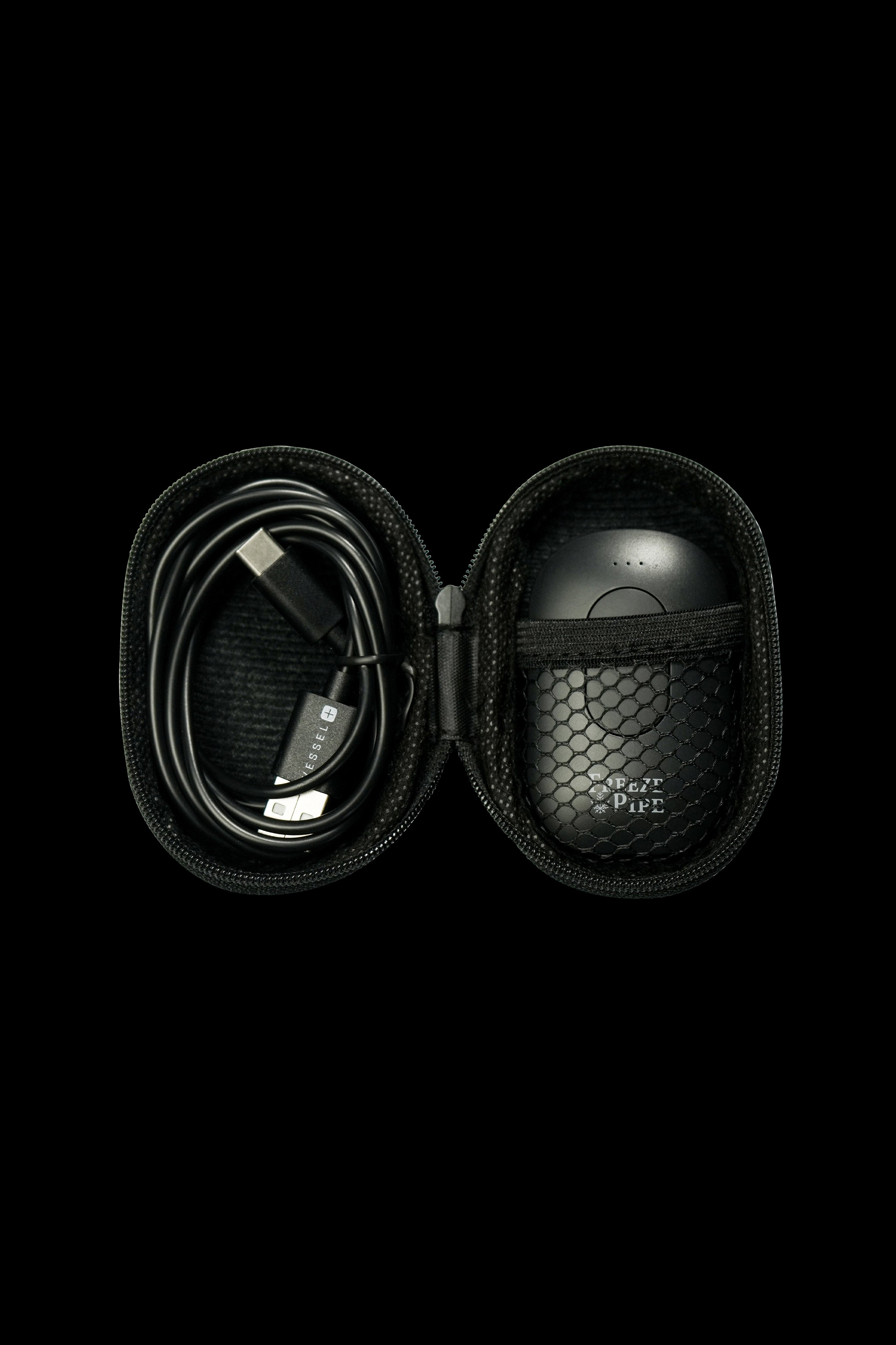Open black carrying case with a cannabis vaporizer and charging cable inside.
