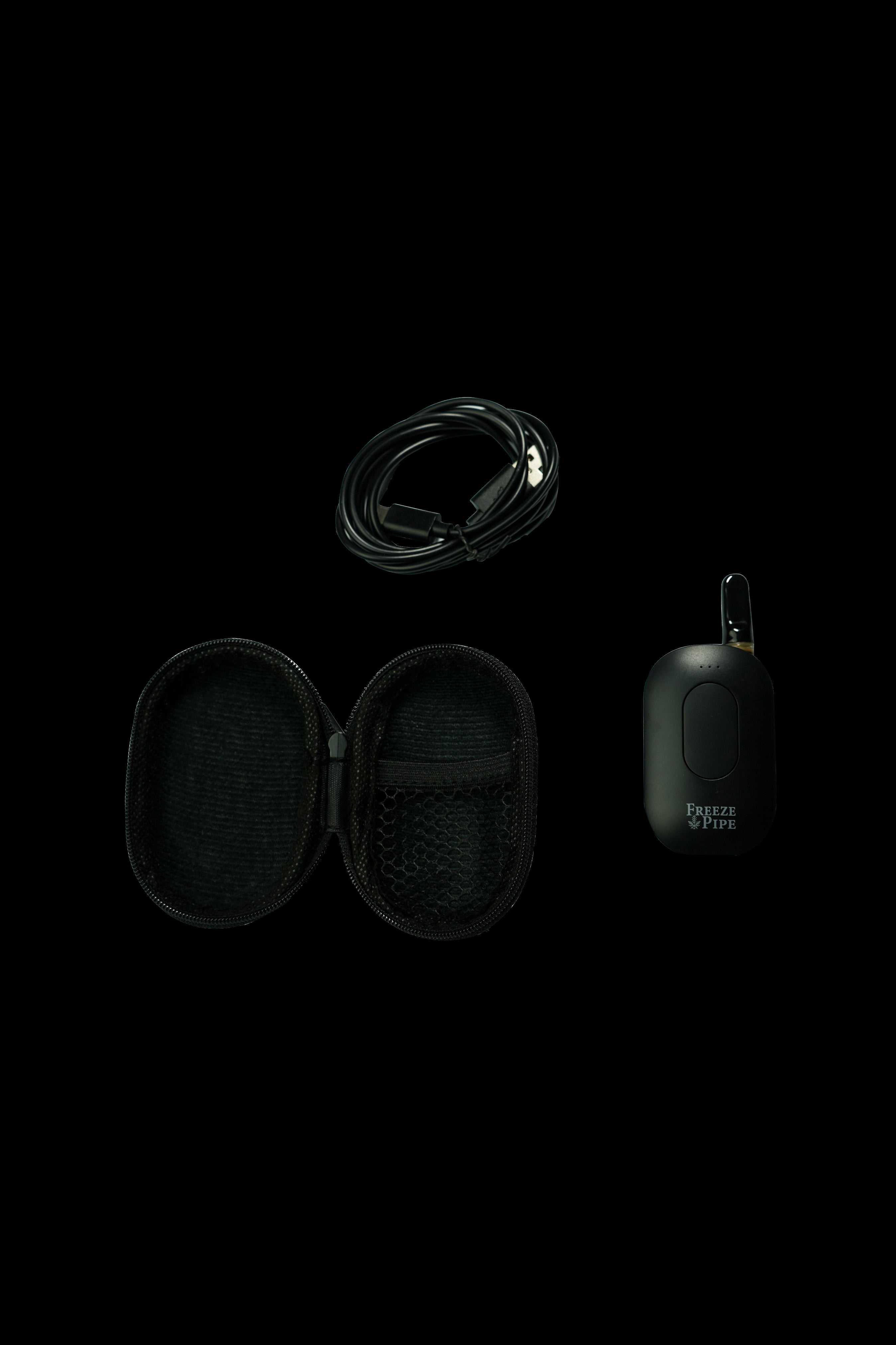 Black Freeze Pipe electronic dab rig with carrying case and USB charging cable on a dark background.