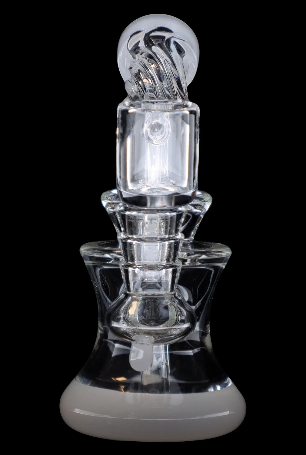 Clear glass dab rig with intricate sculpting and rounded base, isolated on a black background.