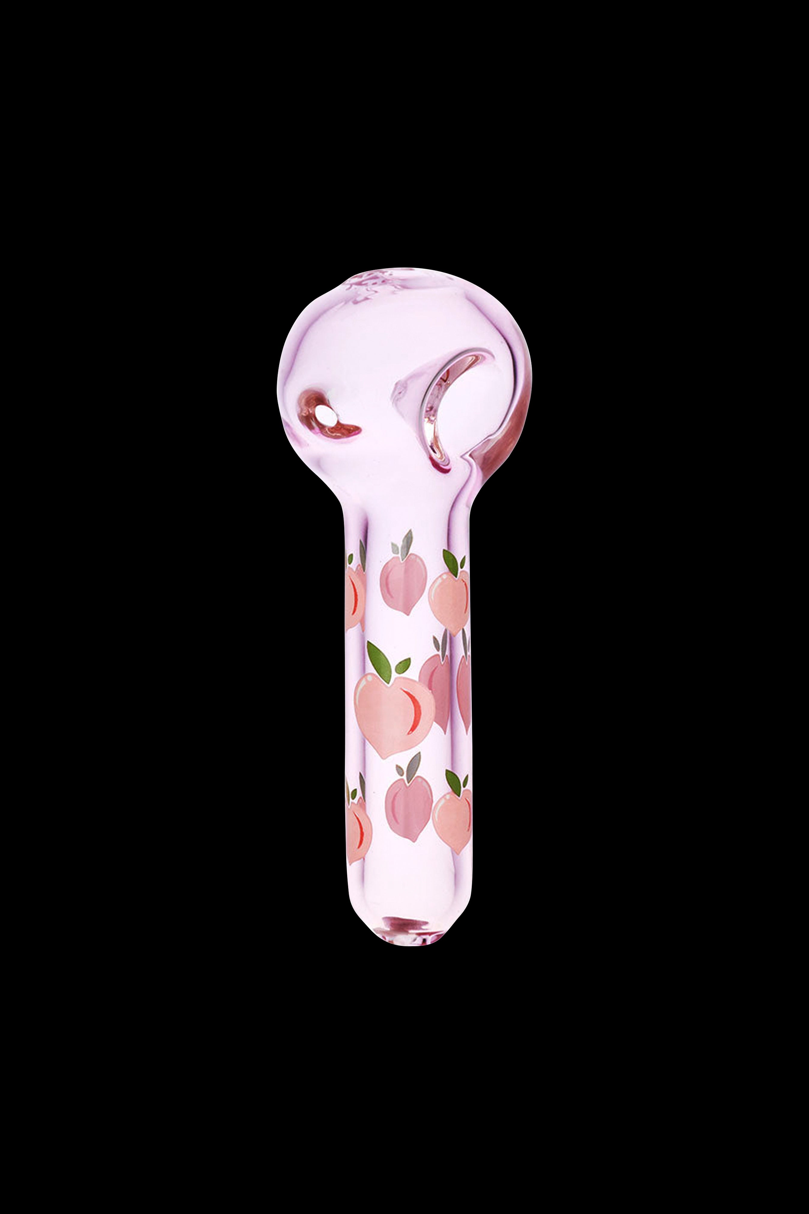 Pink glass pipe with peach pattern against a black background.