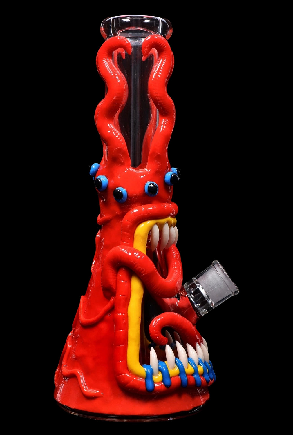 Red glass octopus-shaped water pipe with blue and white teeth, isolated on a black background.