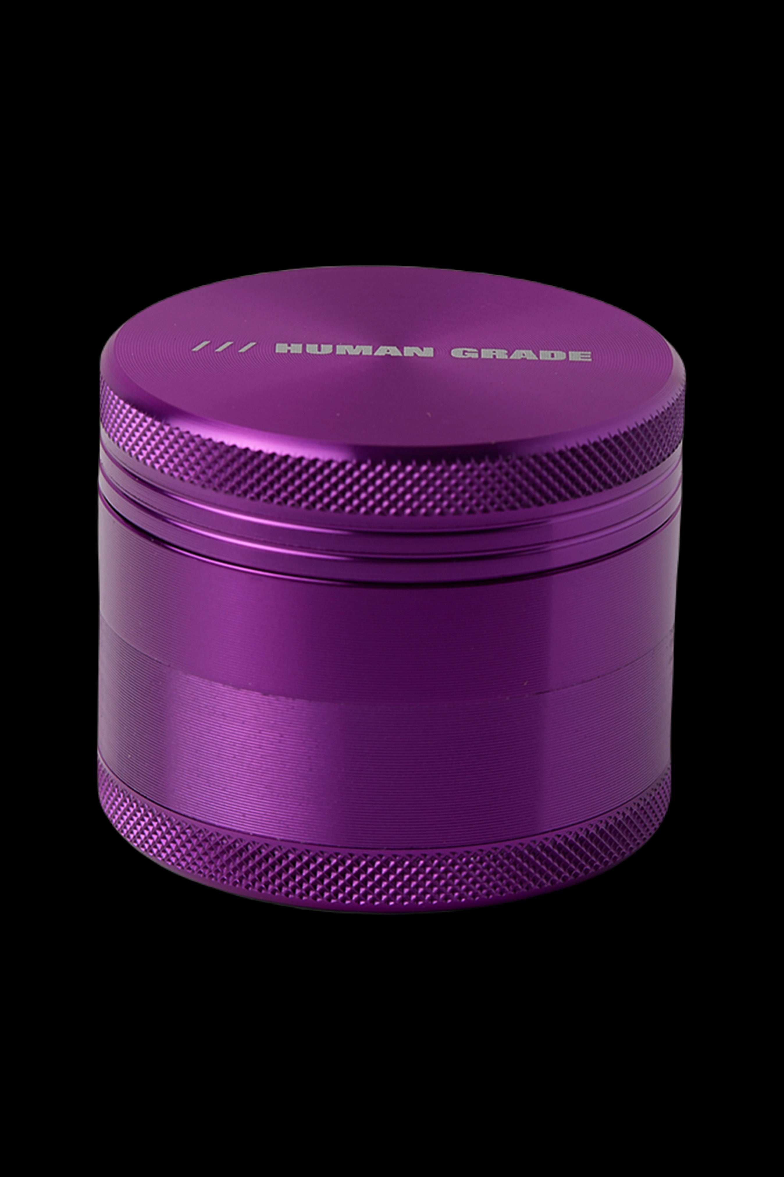 Purple metal cannabis grinder with “HUMAN GRADE” etched on top.
