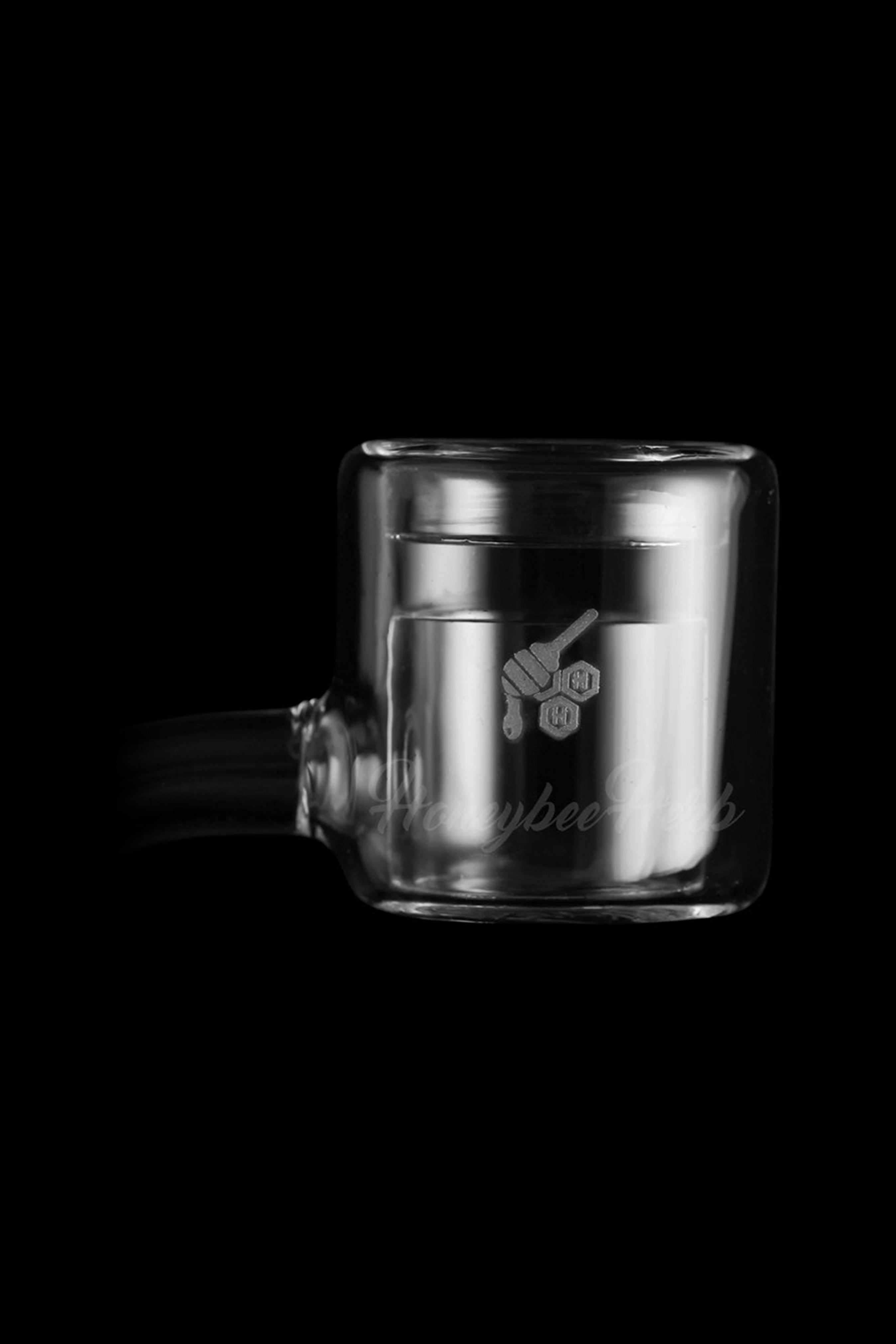 Glass cannabis concentrate container with a graphic of hands holding a honeycomb.