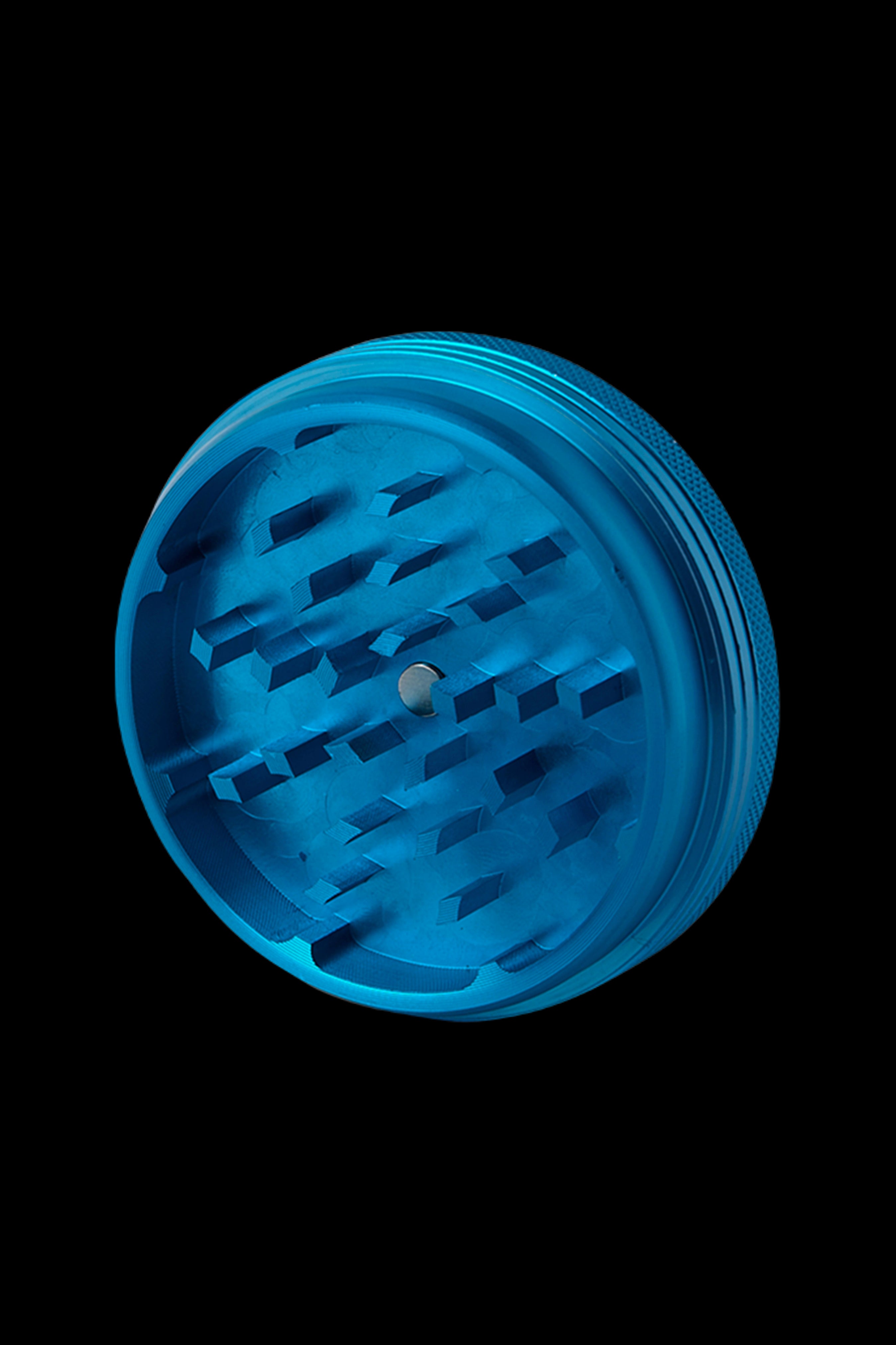 Blue cannabis grinder isolated on a black background.