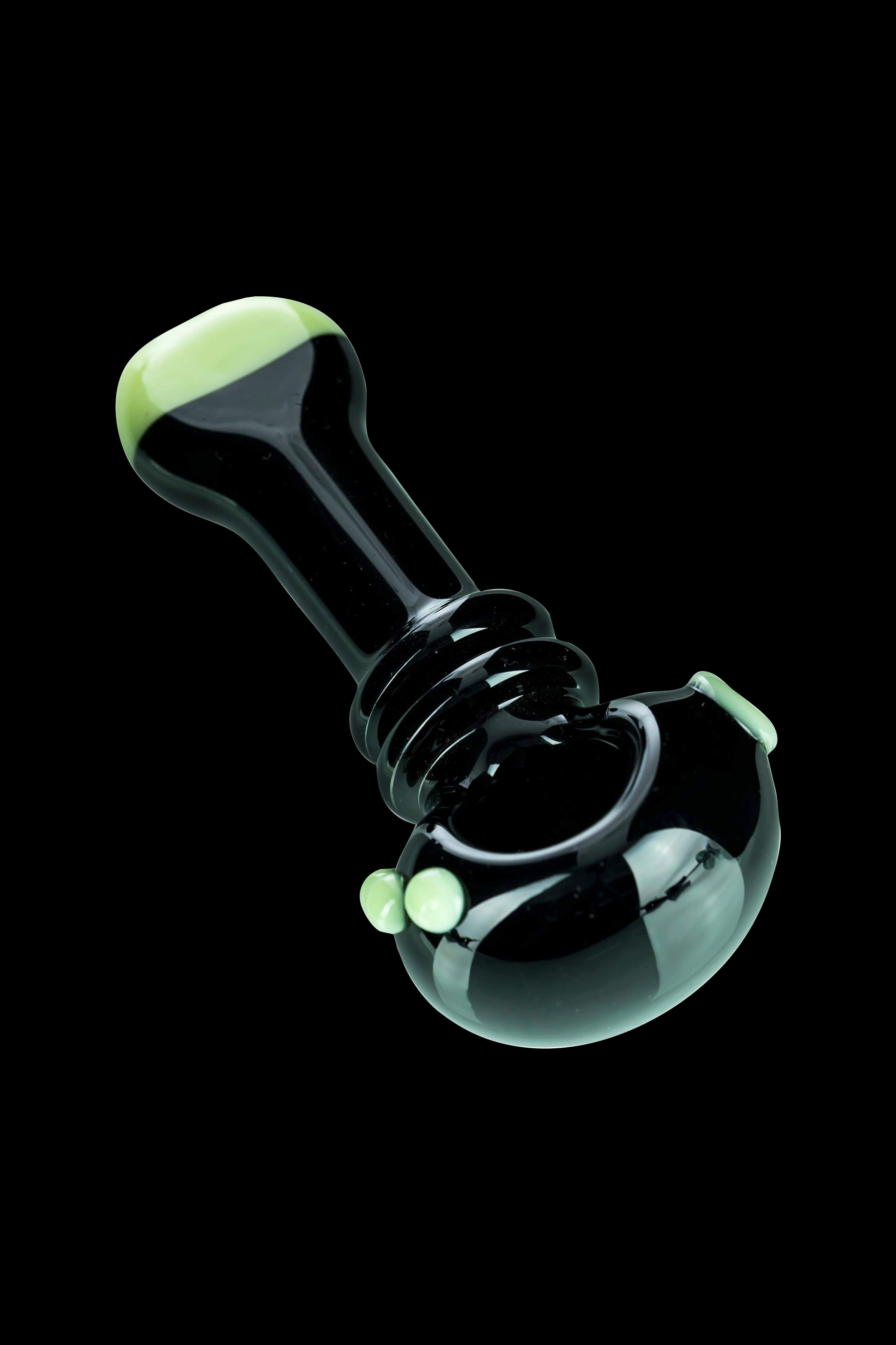 Black glass bubbler with green accents, a type of water pipe for smoking cannabis.