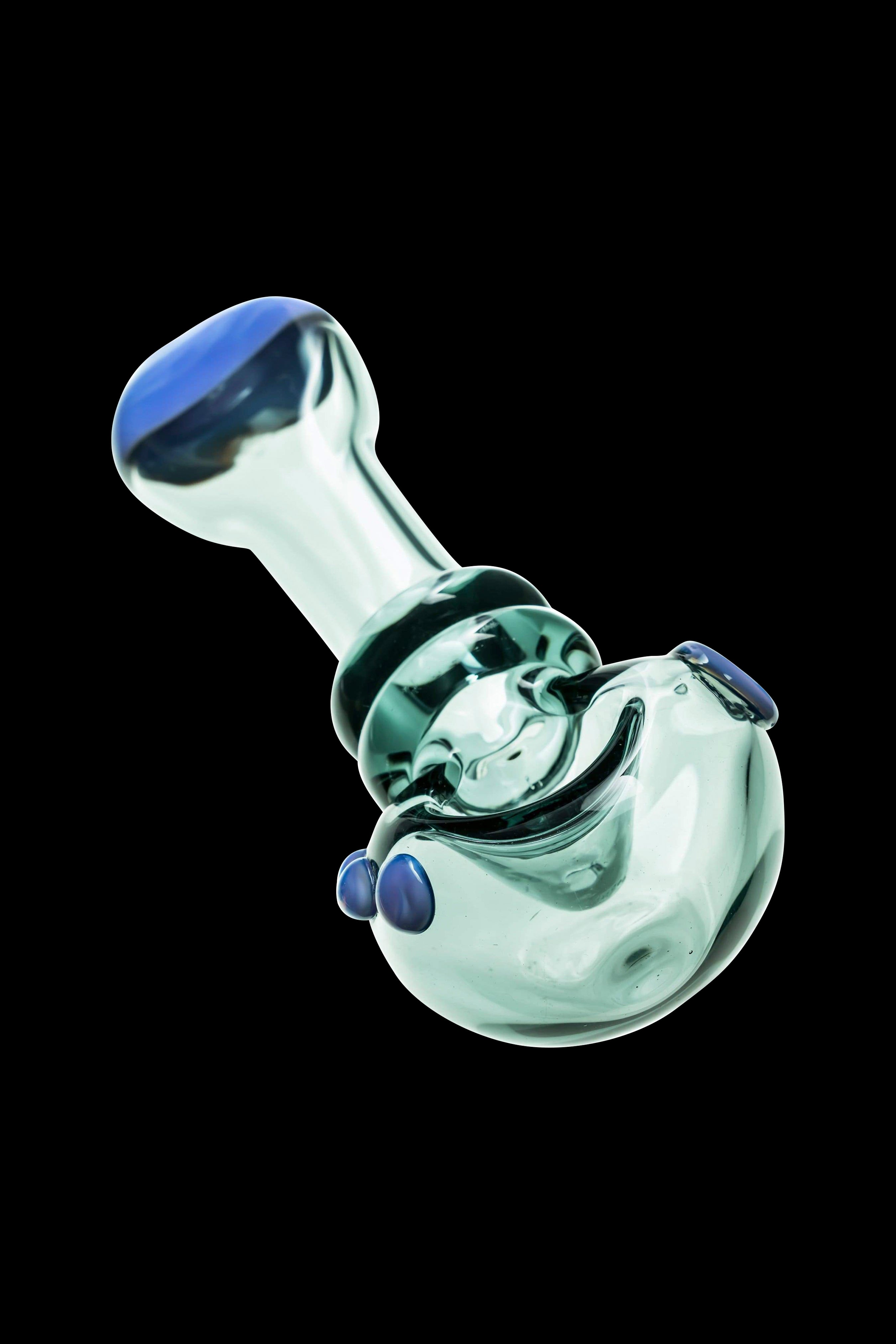 Glass bubbler pipe with blue accents, isolated on a black background.