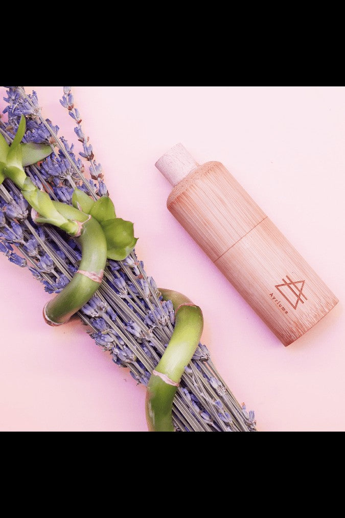 Wooden cannabis oil vape pen alongside sprigs of lavender.