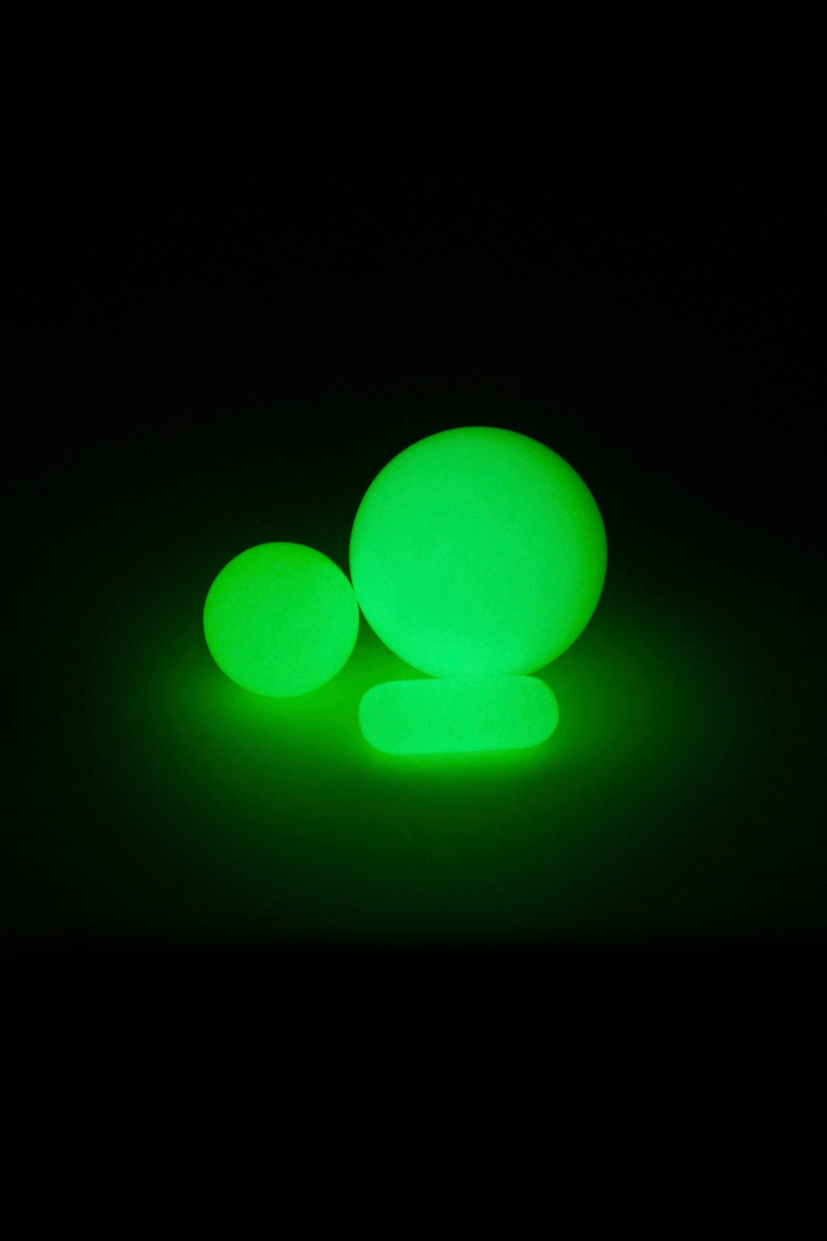 Glowing green spheres resembling cannabis buds against a black background.