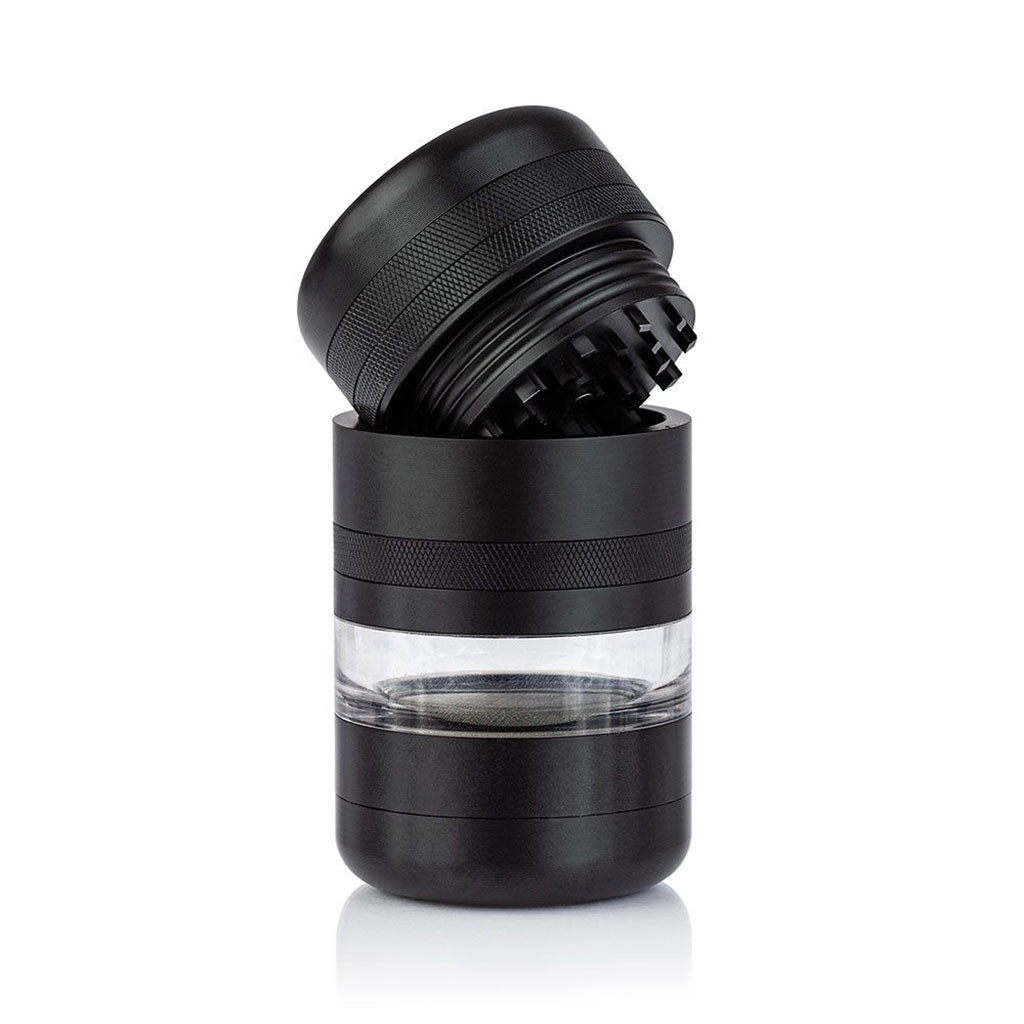 Angled close-up of the black RYOT GR8TR Jar Body Grinder with its top open, showing textured grip and clear middle chamber