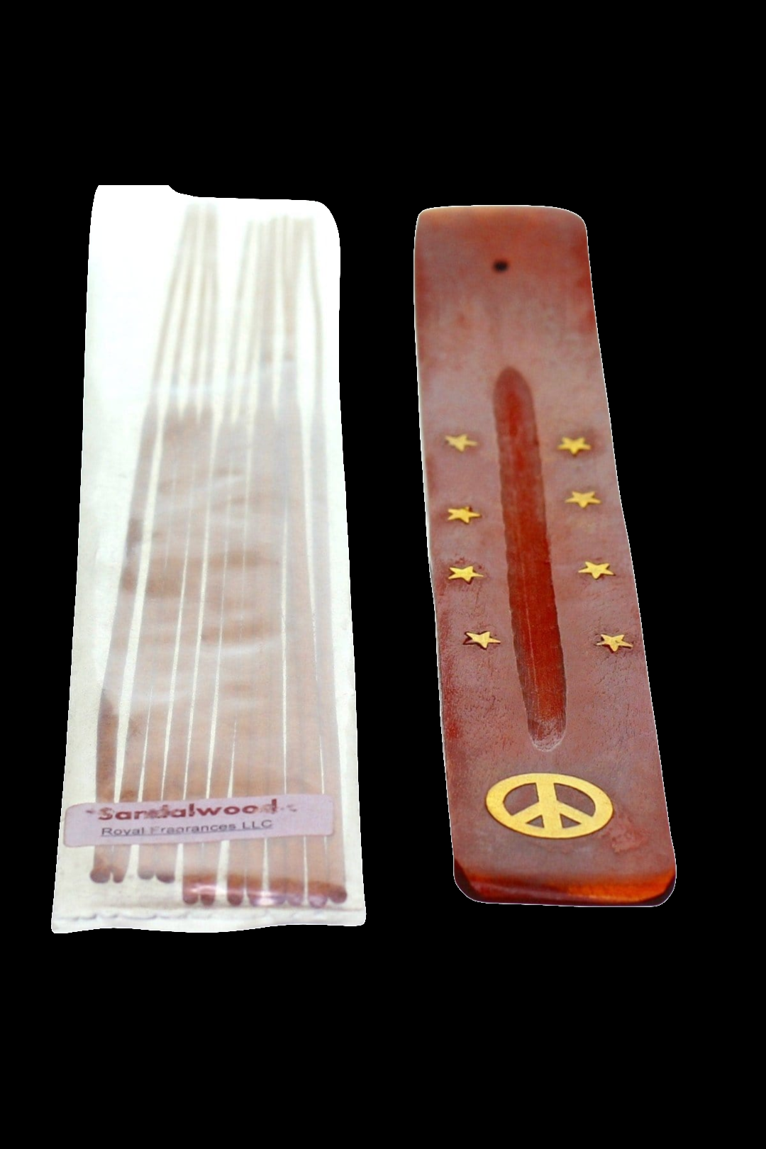 Pack of sandalwood incense sticks next to a peace sign-engraved wooden incense holder.