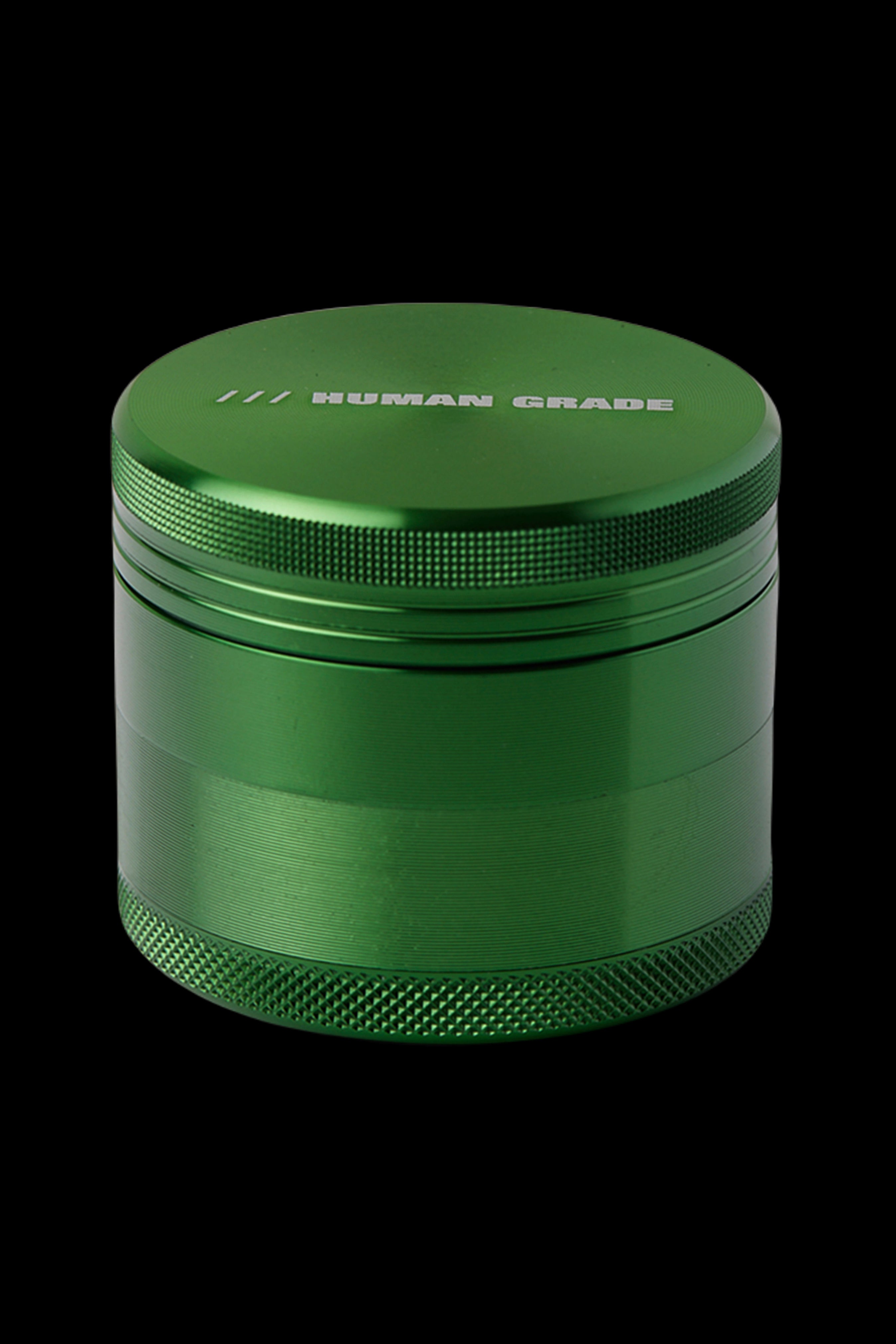 Green four-piece metal cannabis grinder with "HUMAN GRADE" etched on the lid.