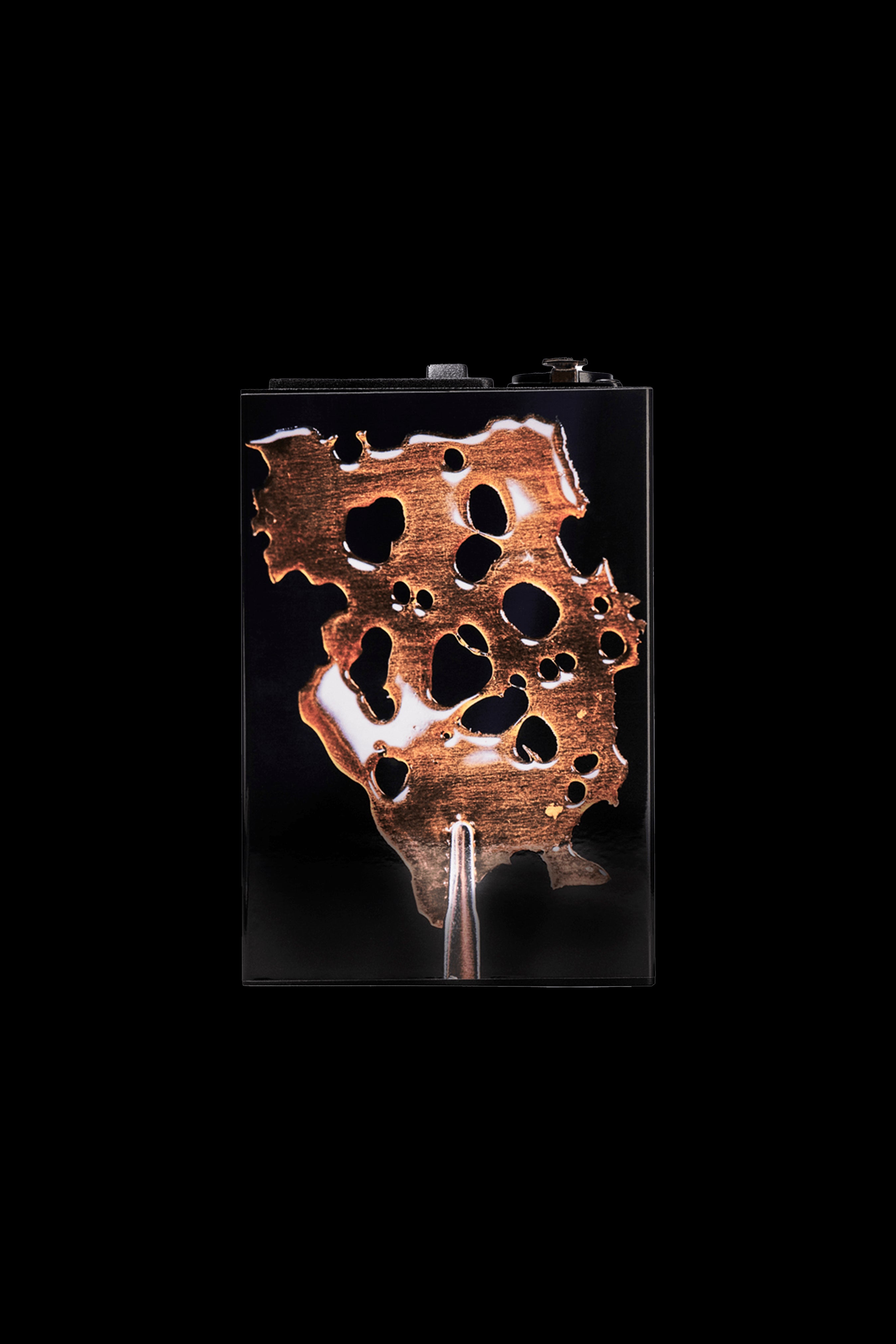 Close-up of a uniquely shaped, bronze-toned cannabis smoking piece displayed in a clear case.