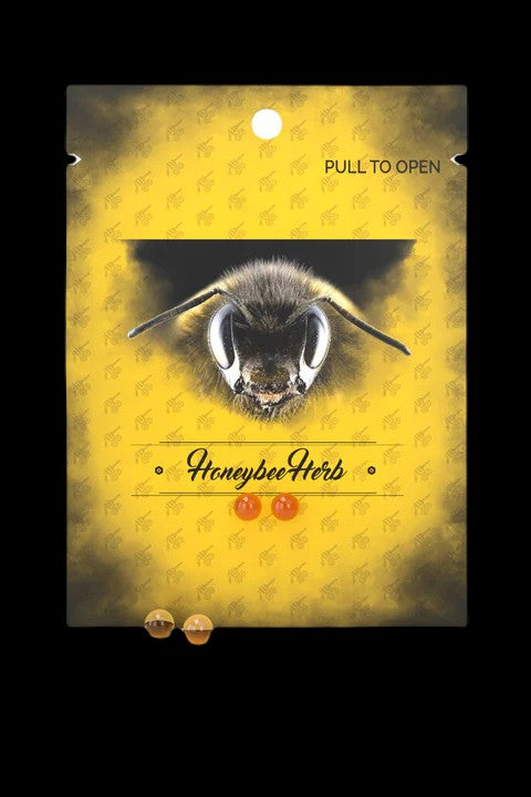Close-up of a bee’s face on a yellow package labeled “HoneybeeHerb” with cannabis bud illustrations, indicating cannabis products.