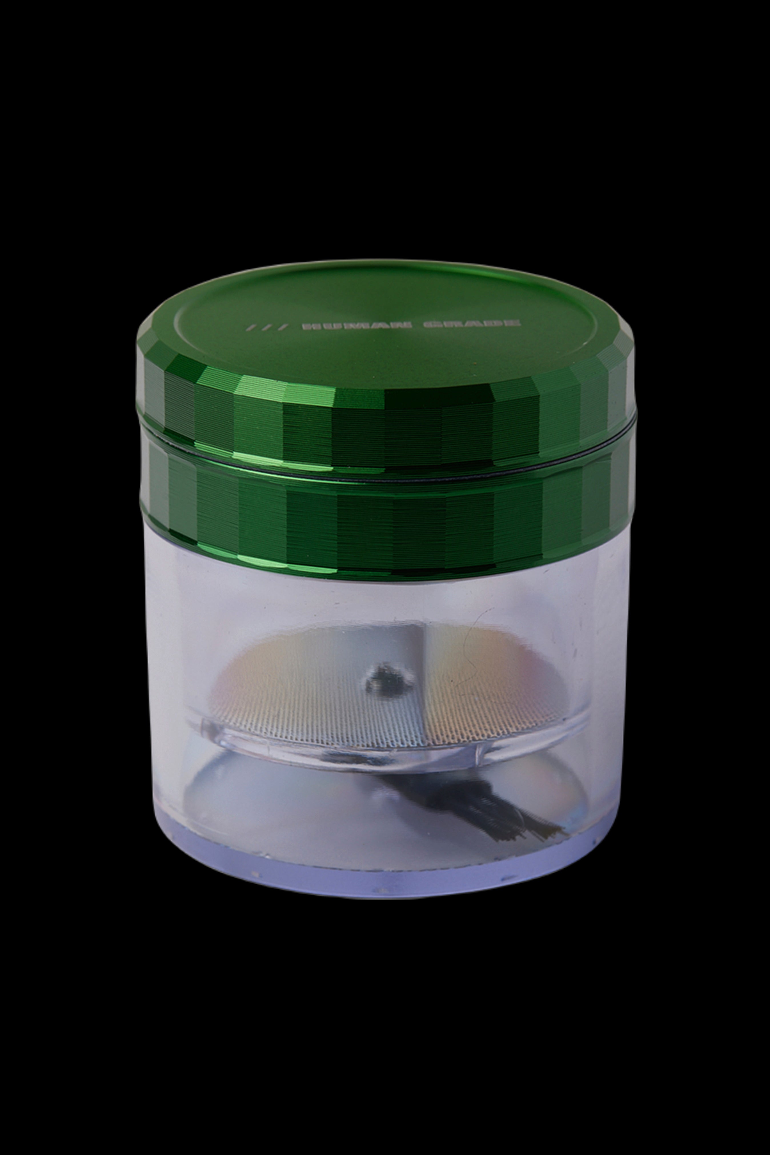 Green and clear cannabis grinder with visible ground herb inside.